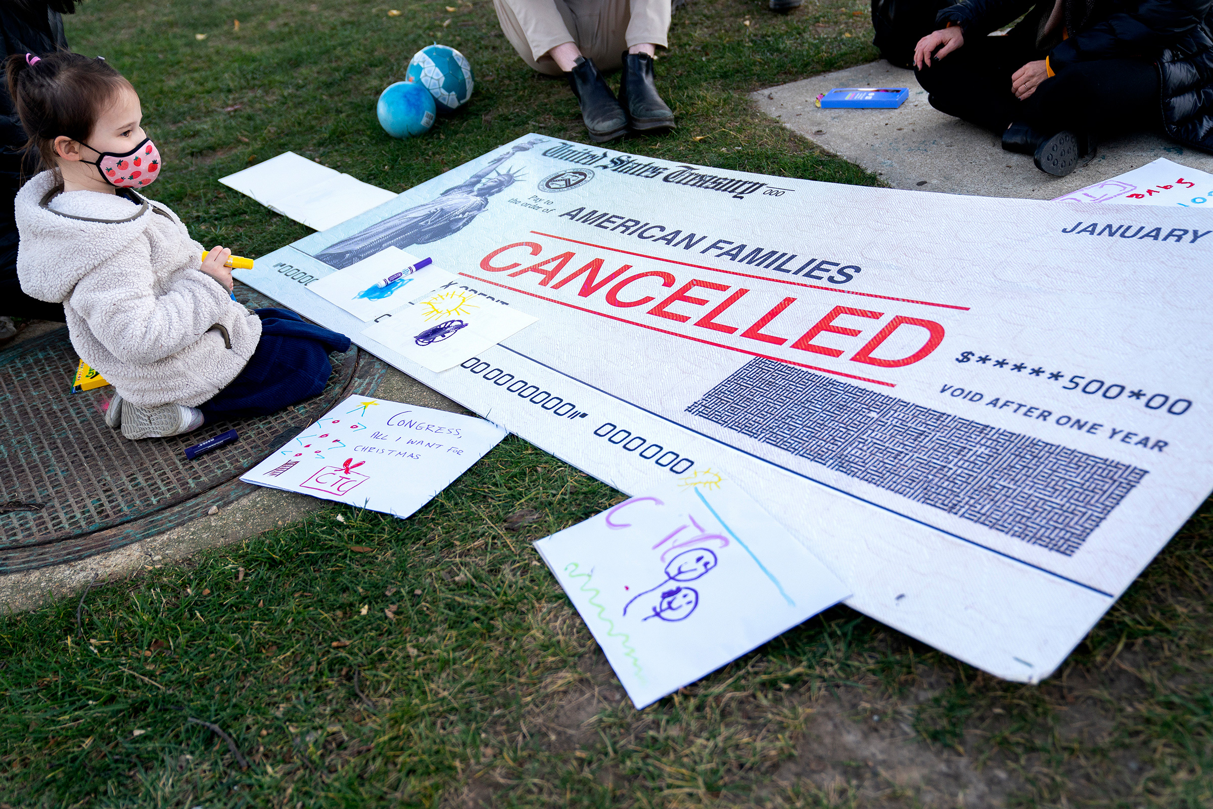 A child sits among activists calling for the extension of the Child Tax Credit outside the Capitol in Washington on Dec. 13, 2021. 