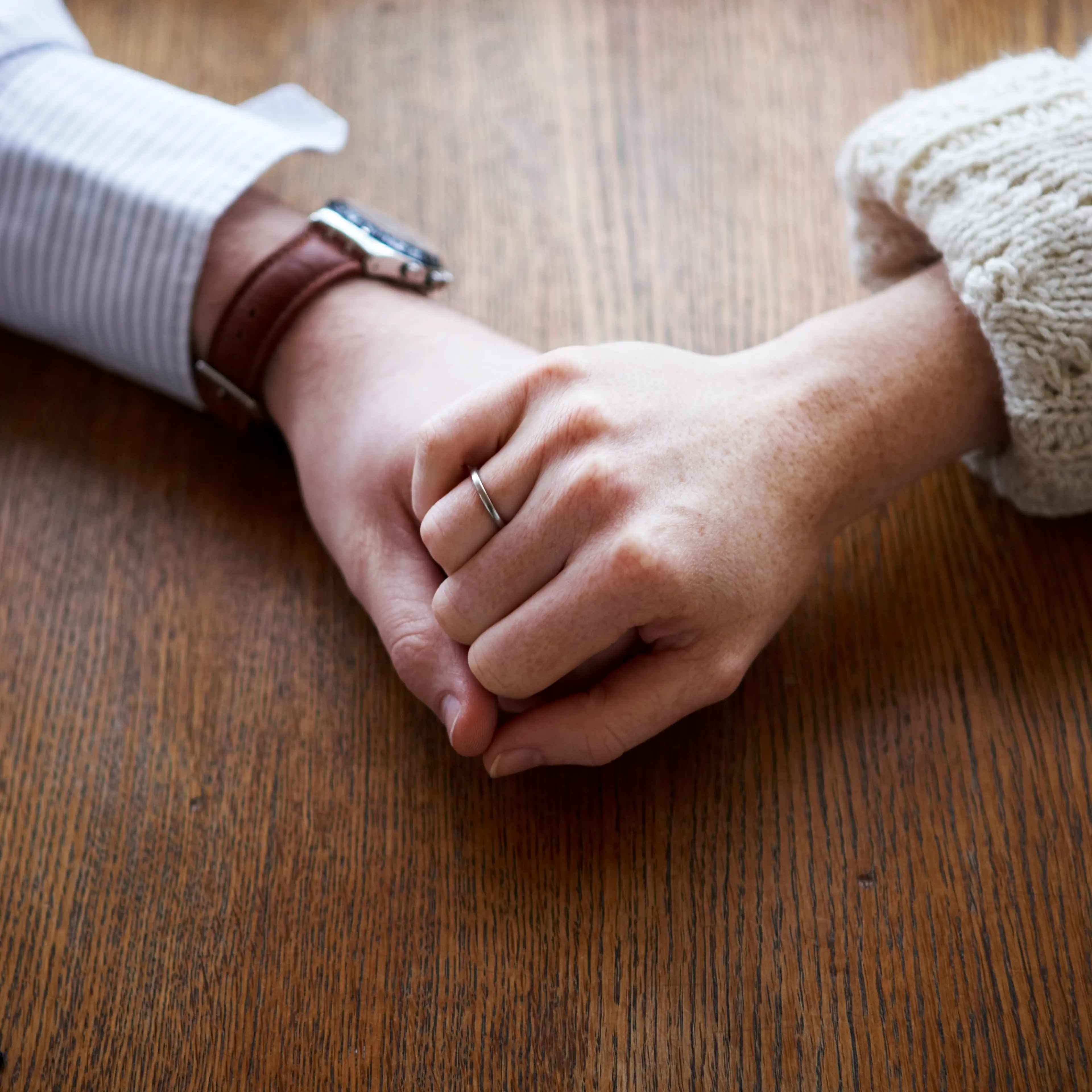 couple-holding-hands-table