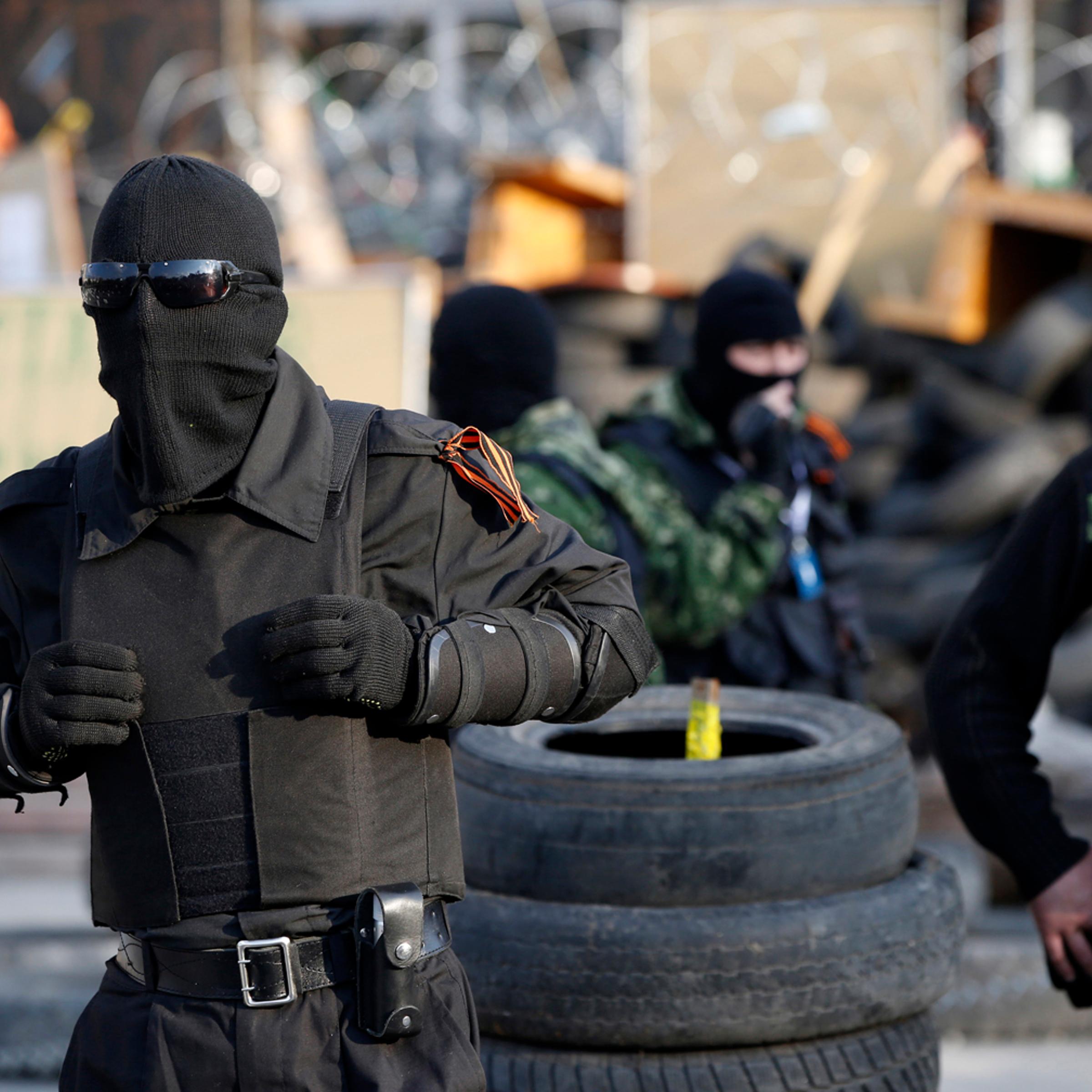 Masked pro-Russia protesters stand guard outside a regional government building in Donetsk