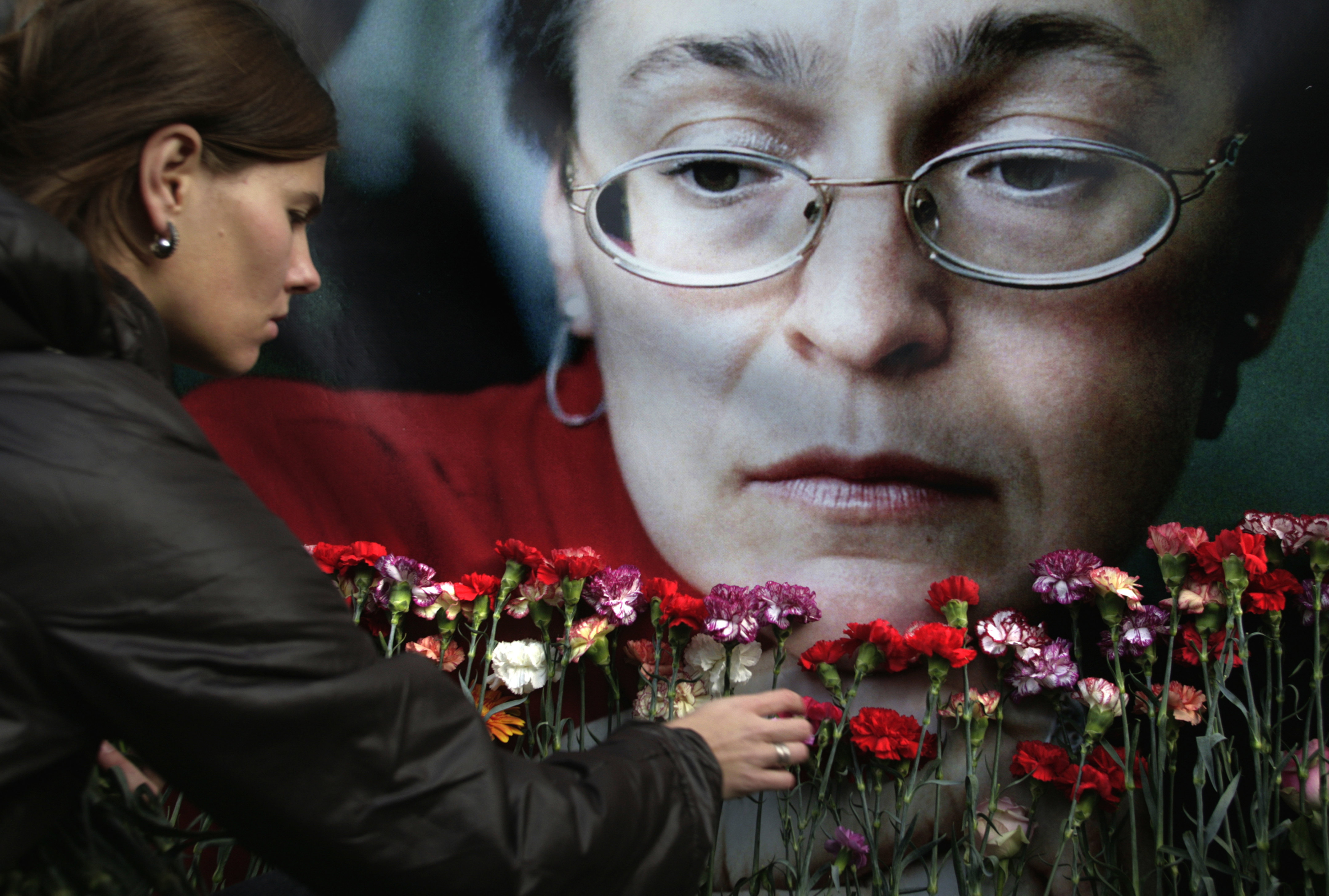 A woman places flowers at a portrait of slain journalist Anna Politkovskaya, during a rally in downtown Moscow, in 2009.