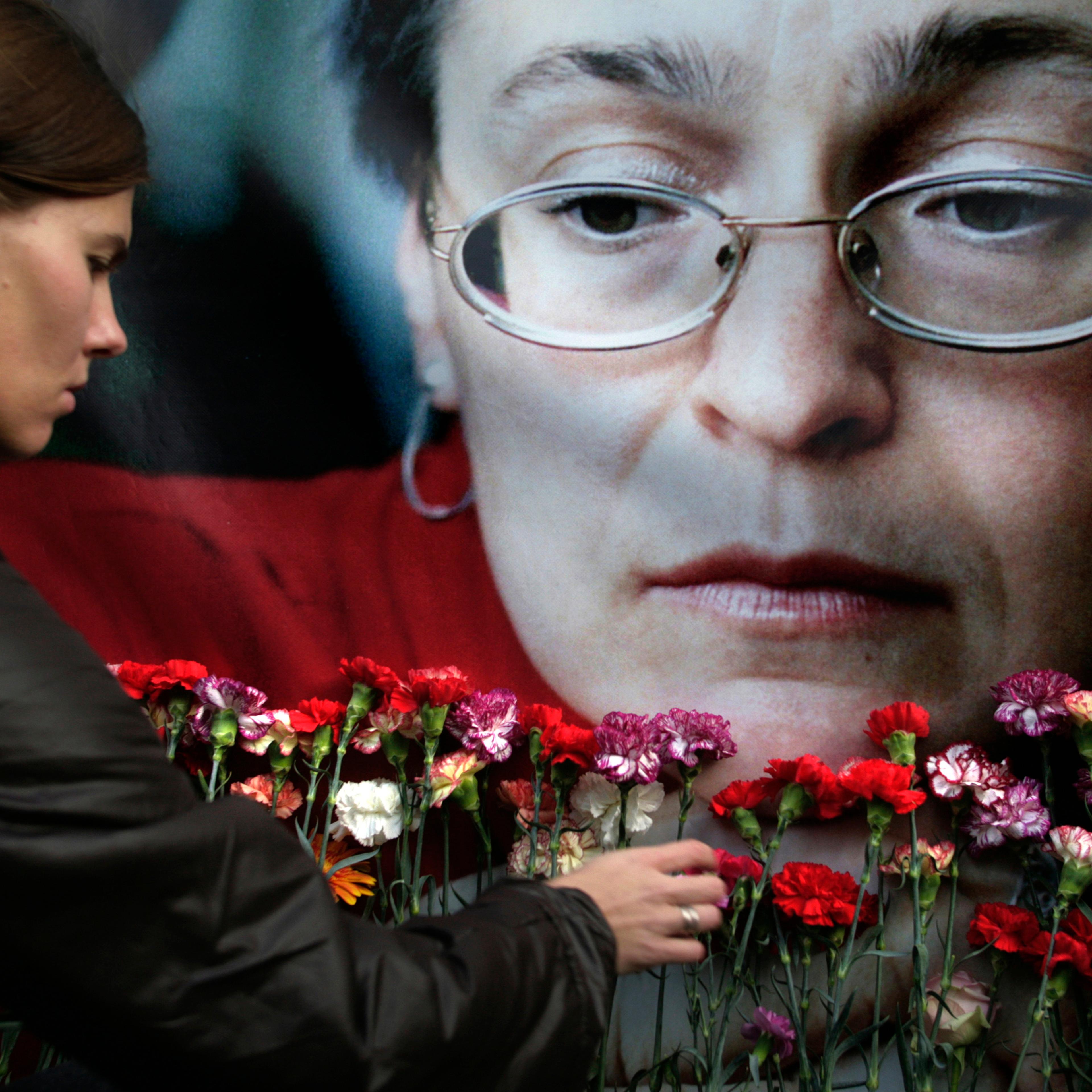 A woman places flowers at a portrait of slain journalist Anna Politkovskaya, during a rally in downtown Moscow, in 2009.