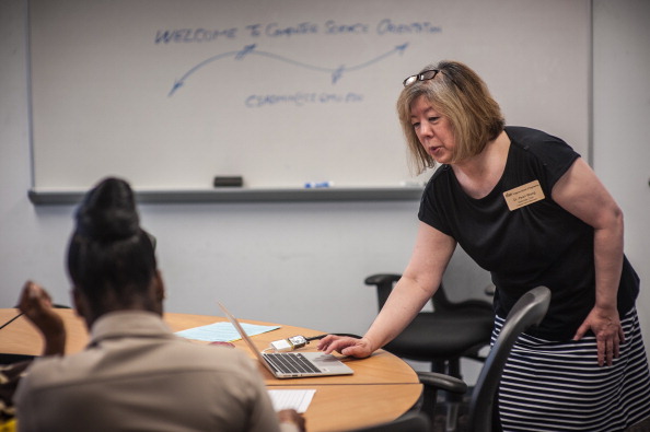 Professor Pearl Wang, Associate Chair of the Computer Science department at George Mason University, speaks with Khadija Allotey, 22, a transfer student from Strayer University, during an orientation session.