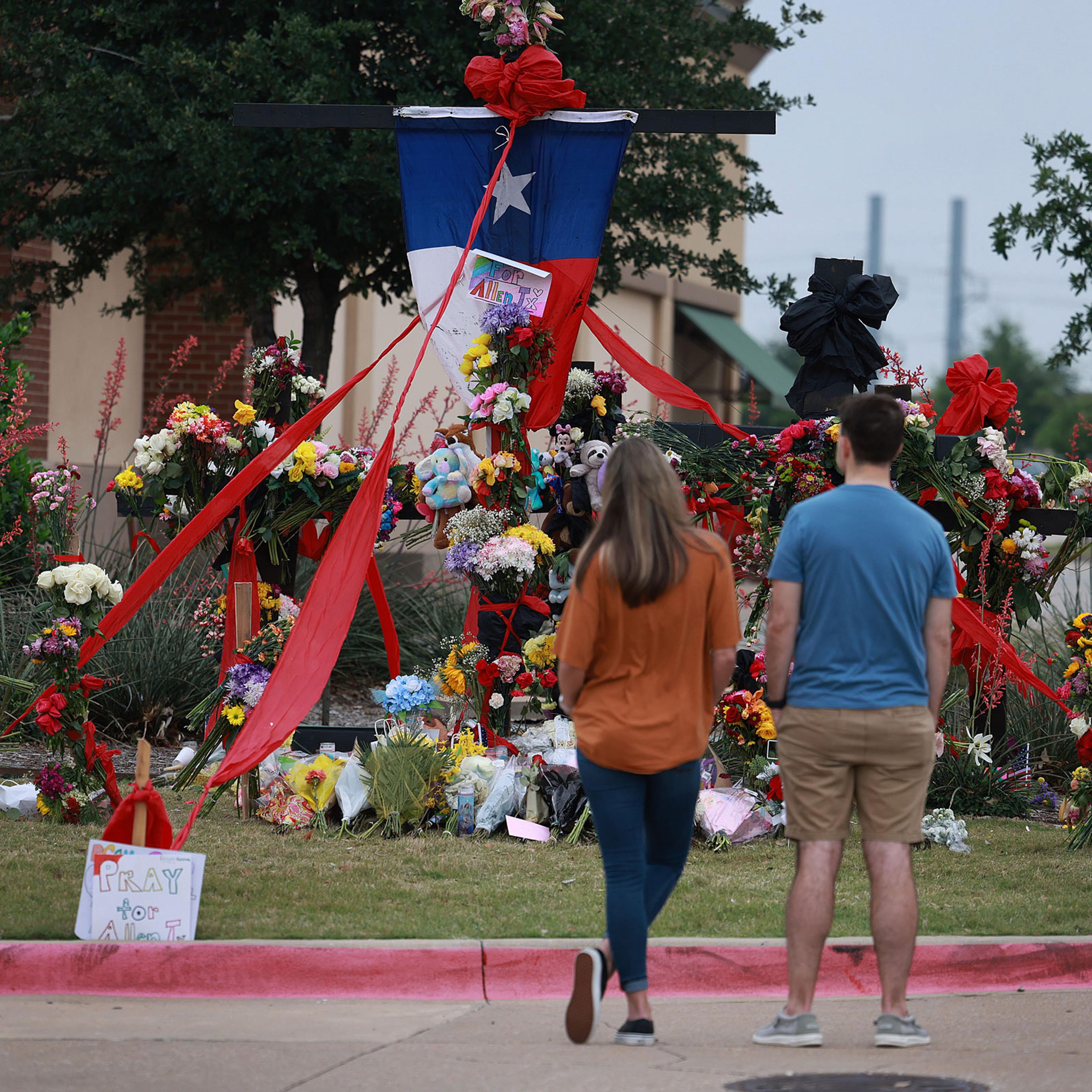 People look at a memorial to those killed at the Allen Premium Outlets mall after the mass shooting in Allen, Texas