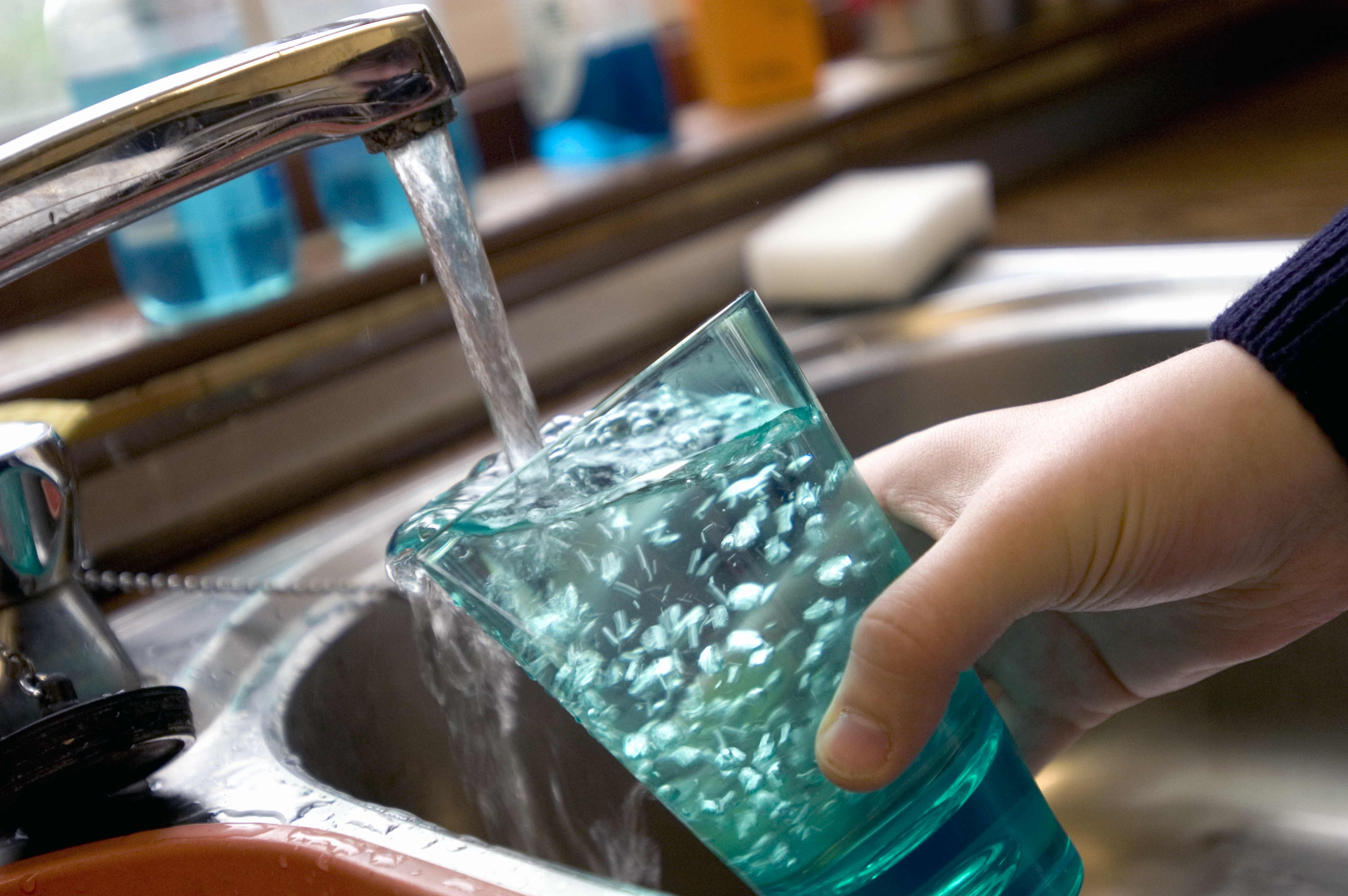 Child filling glass with tap water UK