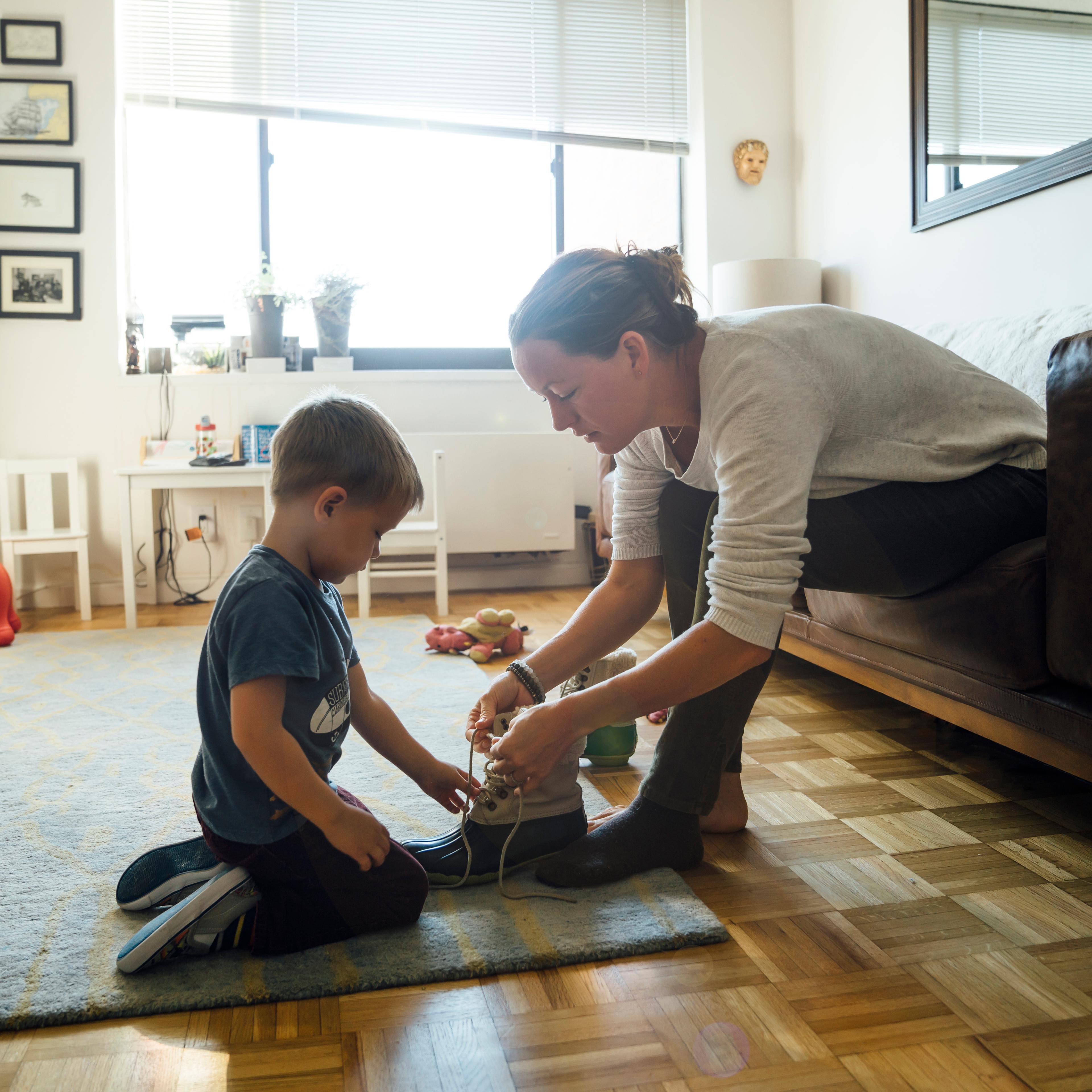Mother teaching son to tie shoelace