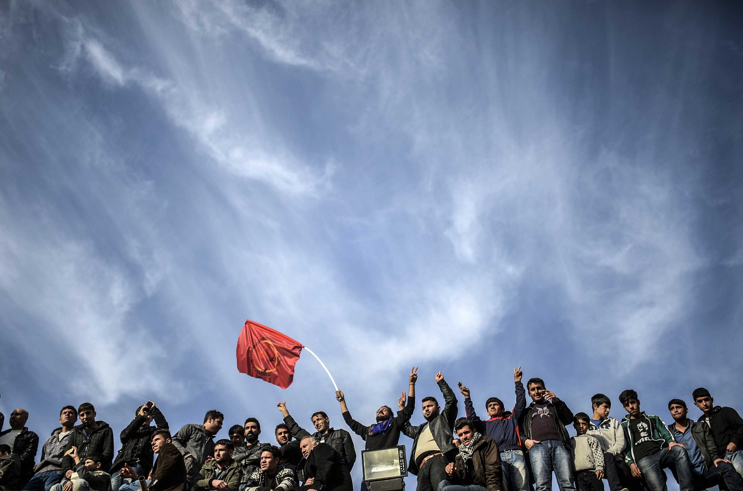 Kurdish people celebrate near the Turkish-Syrian border in Suruc, in Sanliurfa province in Turkey on Jan. 27, 2015.