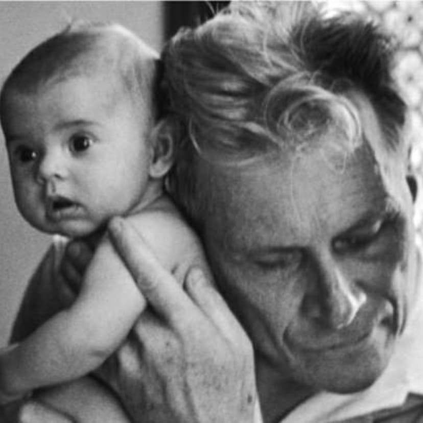 Blind doctor Albert-Andre Nast holds his ear to the back of a 3-month old instead of using a stethoscope, France, 1953.