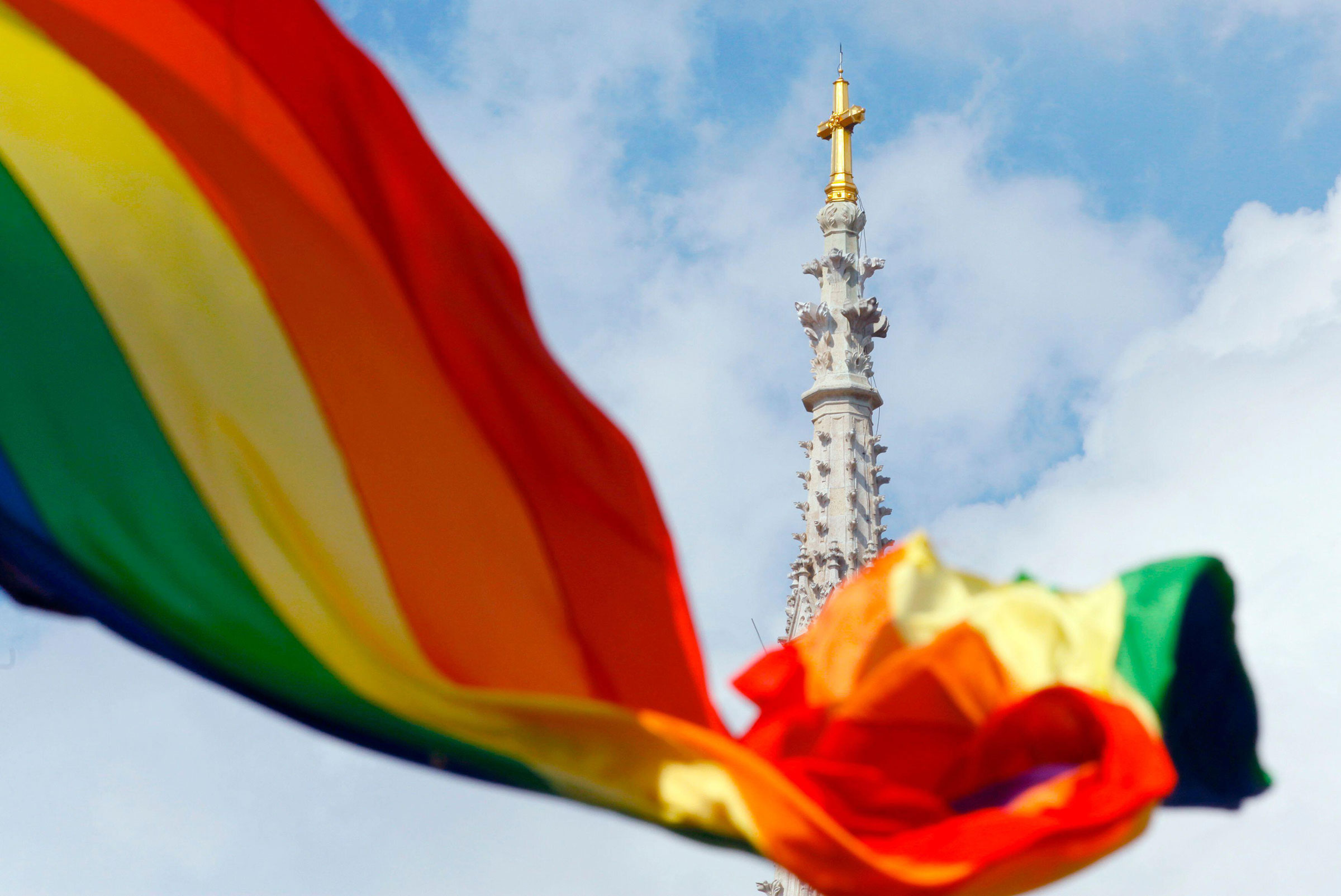 A rainbow flag is seen in front of a church.