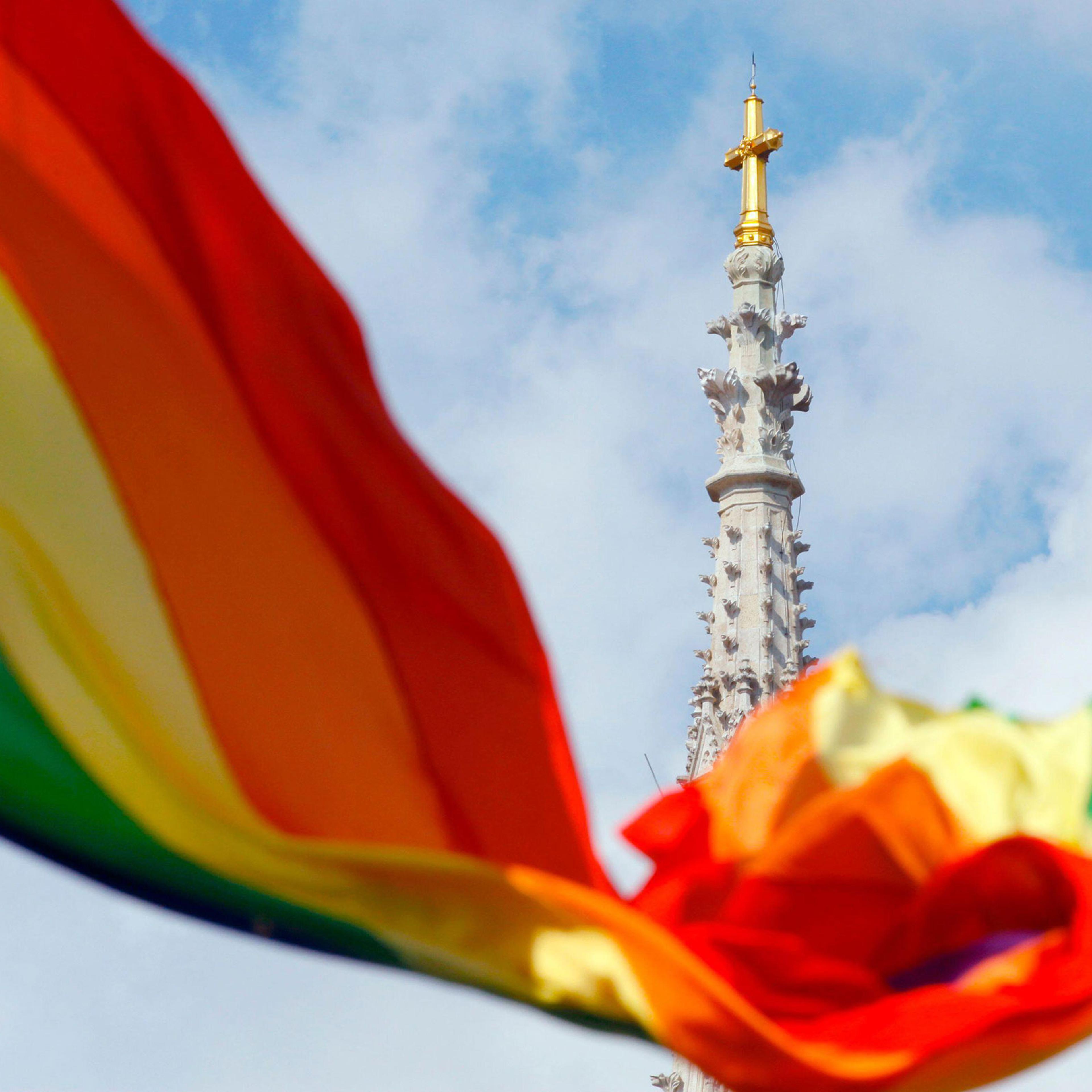 A rainbow flag is seen in front of a church.