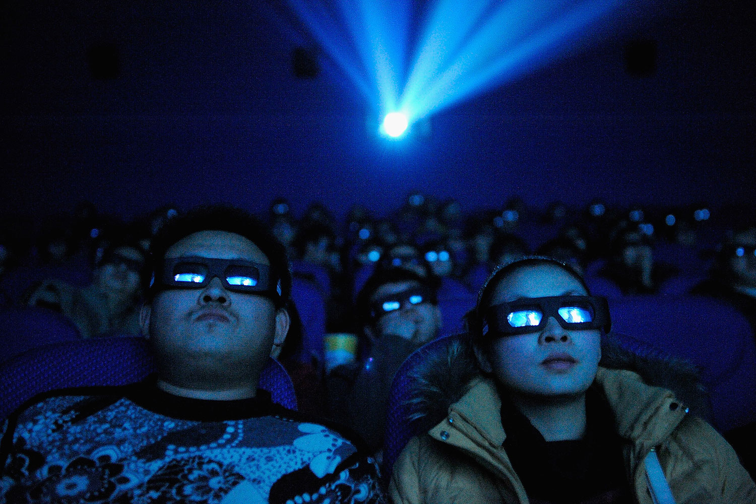 A Chinese cinema audience watches a movie through 3D glasses