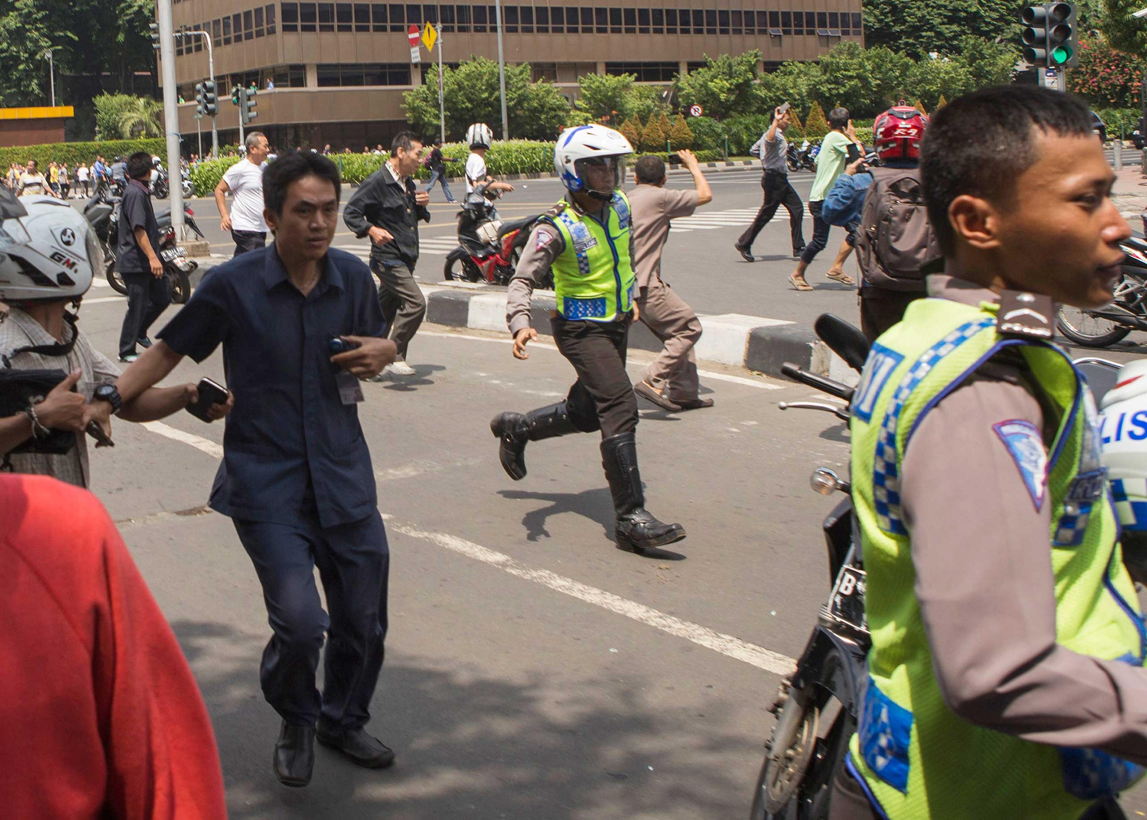 People flee from the scene after a gun battle broke out following an explosion in Jakarta, Indonesia, Jan. 14, 2016.