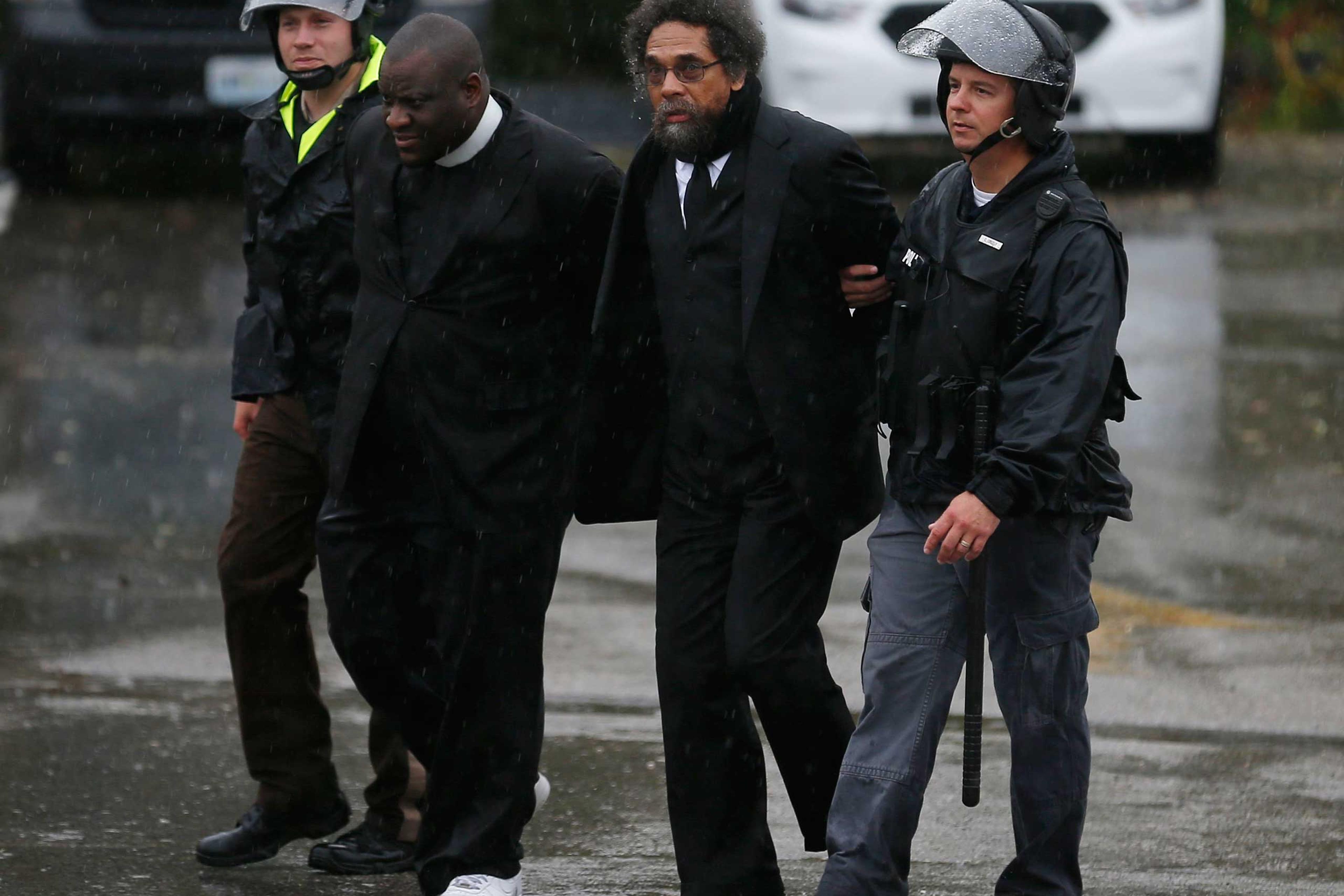 Activist Cornel West is detained by police during a protest at the Ferguson Police Department in Ferguson