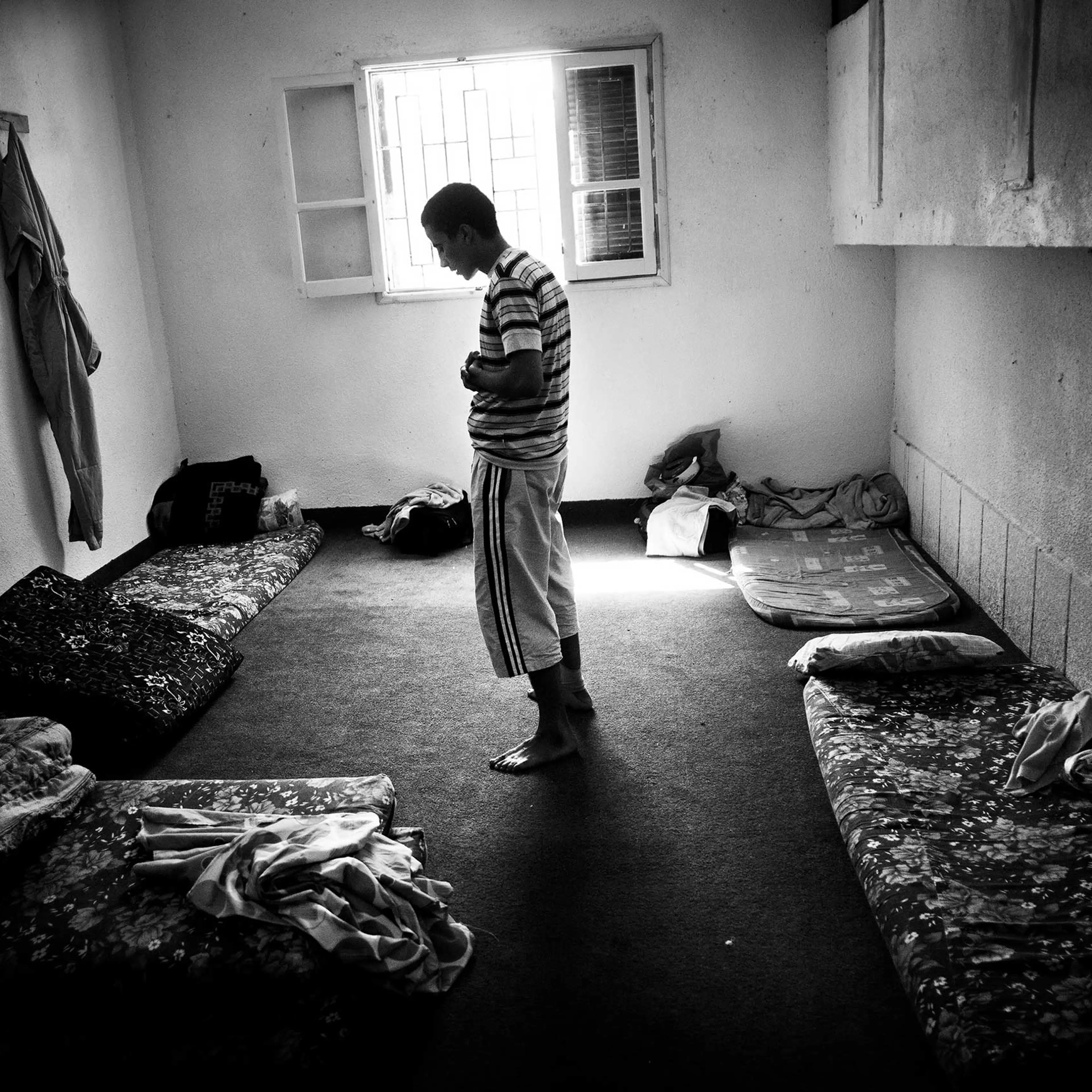 Suspected of being a Gaddafi loyalist prays at her cage in a school run by militias as a temporary prison in Misratah, Libya, Sep. 2011.