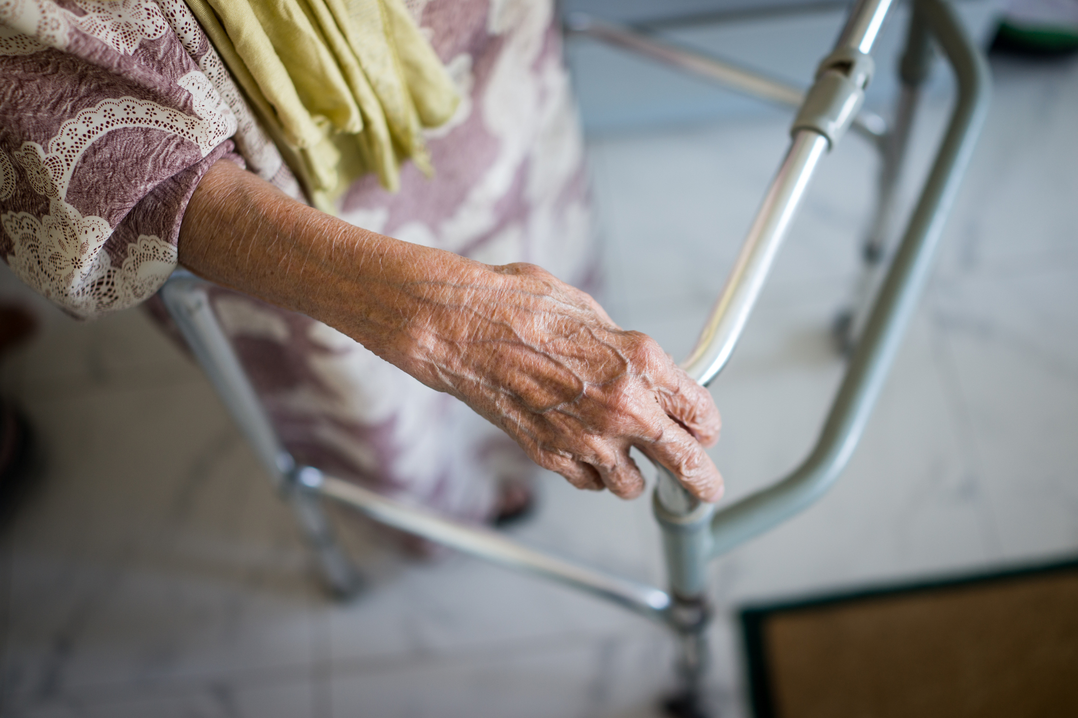 An old woman uses a walker