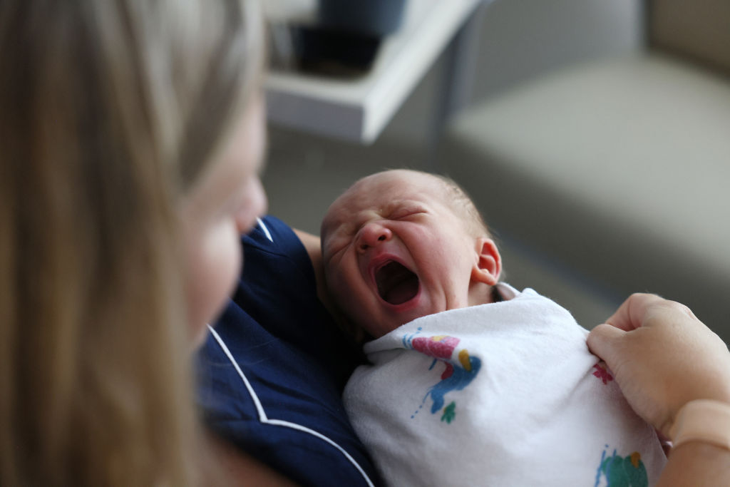 A newborn baby boy yawns as he sits with his mother at Emerson Hospital in Concord, MA. 