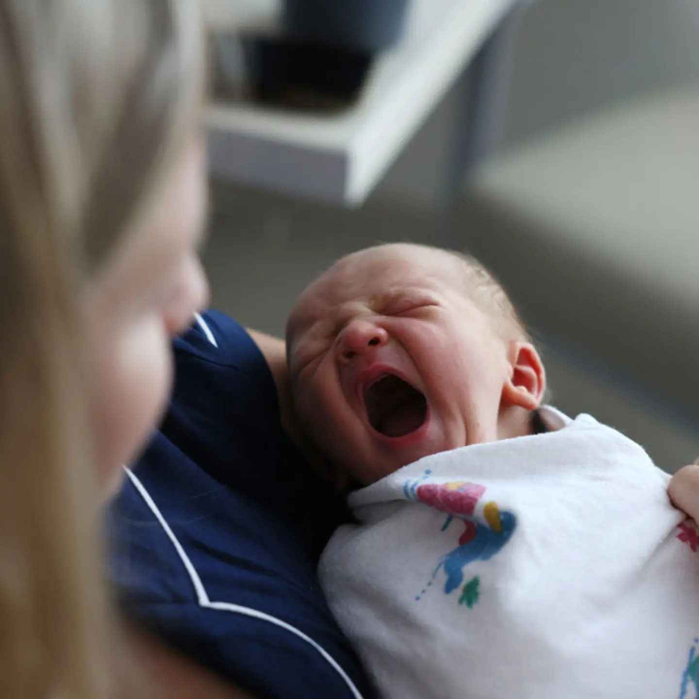 A newborn baby boy yawns as he sits with his mother at Emerson Hospital in Concord, MA.