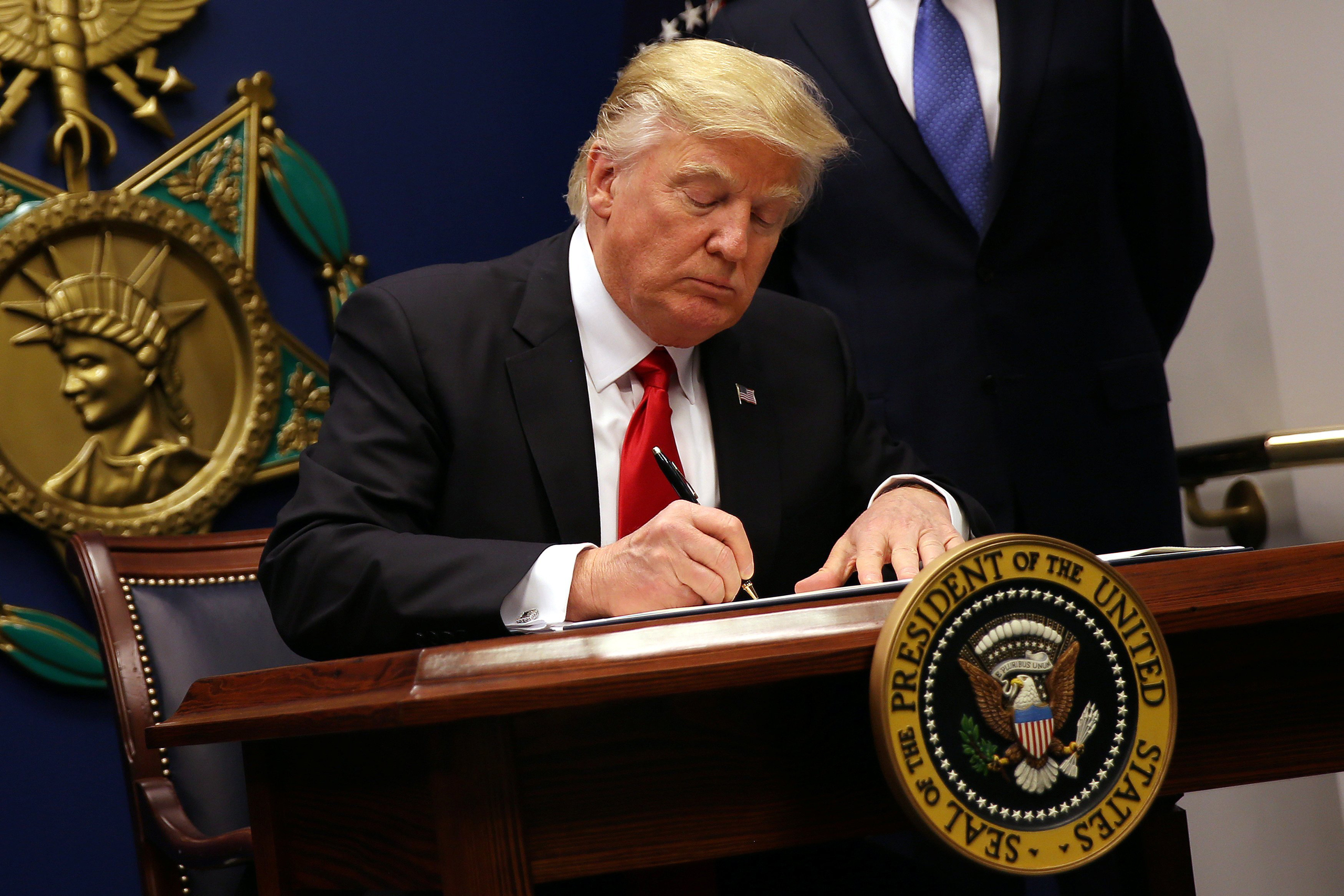U.S. President Donald Trump signs an executive order to impose tighter vetting of travelers entering the United States, at the Pentagon in Washington, U.S., January 27, 2017. The executive order signed by Trump imposes a four-month travel ban on refugees