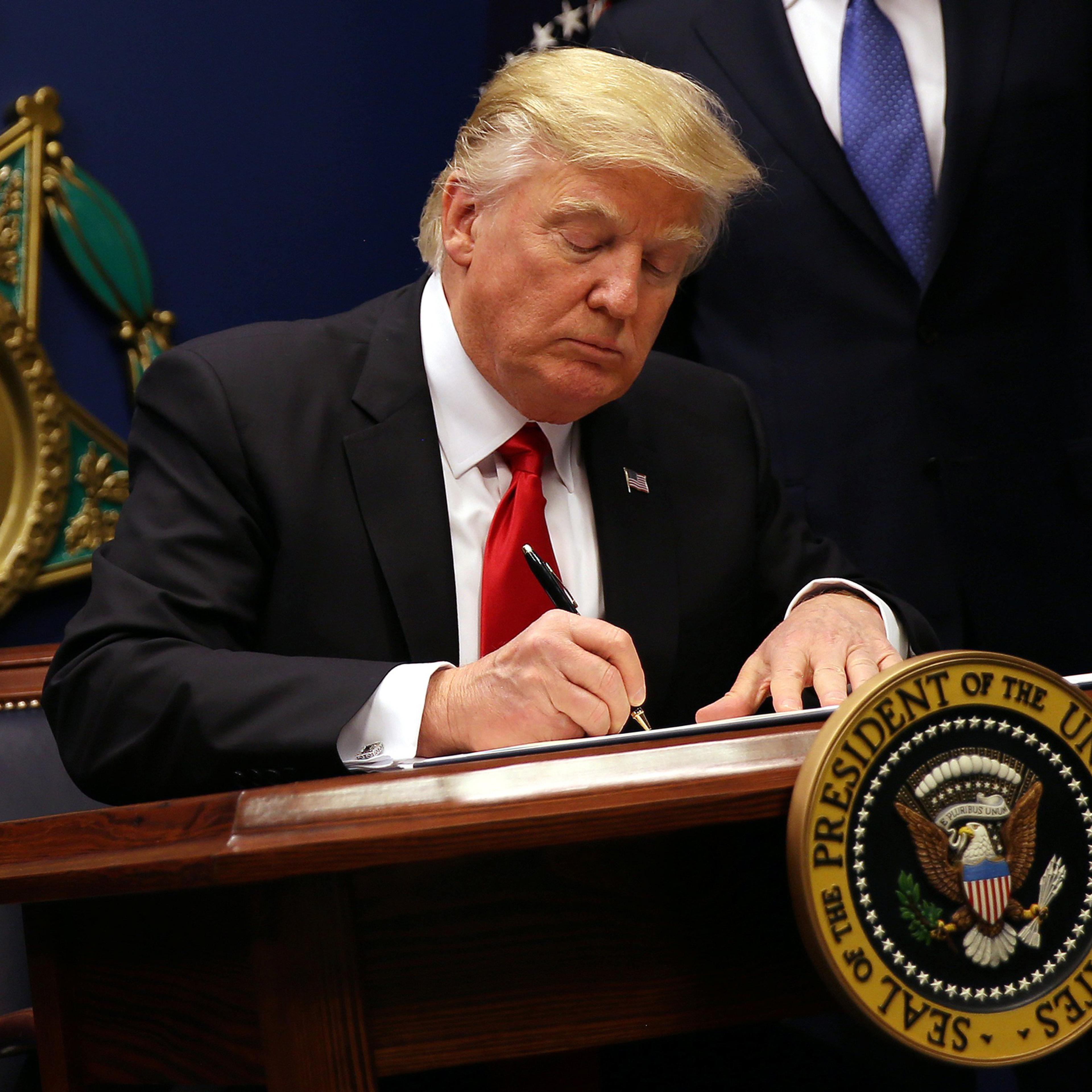 U.S. President Donald Trump signs an executive order to impose tighter vetting of travelers entering the United States, at the Pentagon in Washington, U.S., January 27, 2017. The executive order signed by Trump imposes a four-month travel ban on refugees
