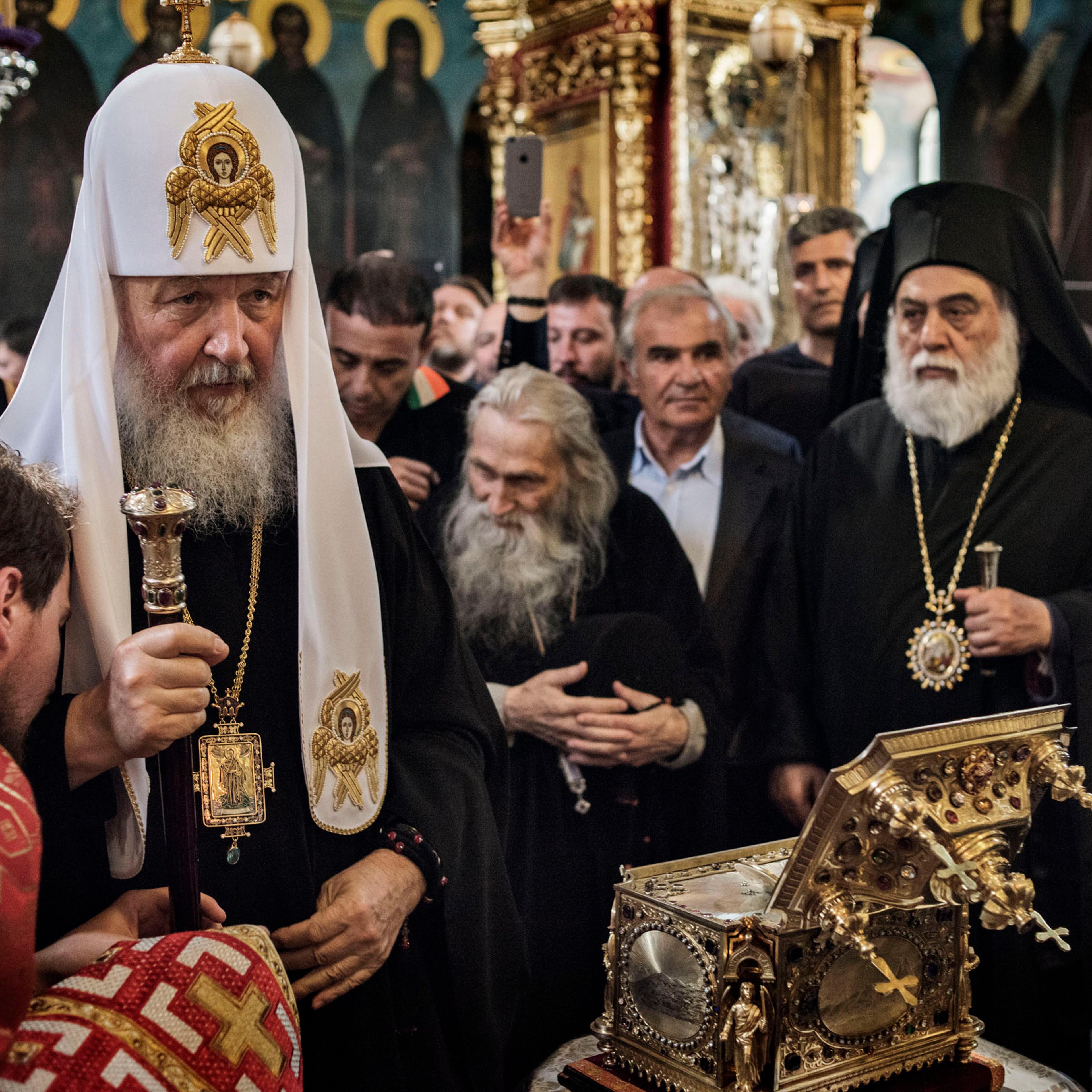 Patriarch Kirill of the Russian Orthodox Church stands before the reliquary, a bejeweled box containing a holy relic, at the main church in St. Panteleimon, the Russian monastery on Mount Athos, in northern Greece, May 27, 2016. Behind him bows the abbot