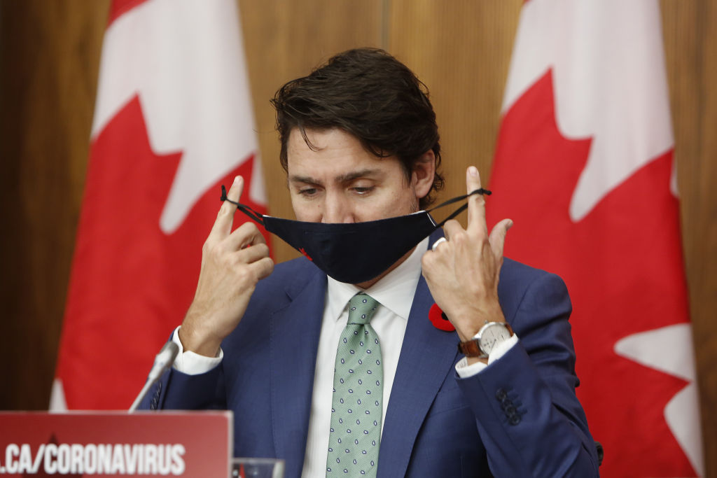 Justin Trudeau, Canada's prime minister, takes off a protective mask during a news conference in Ottawa, Ontario, Canada, on Friday, Nov. 6, 2020.