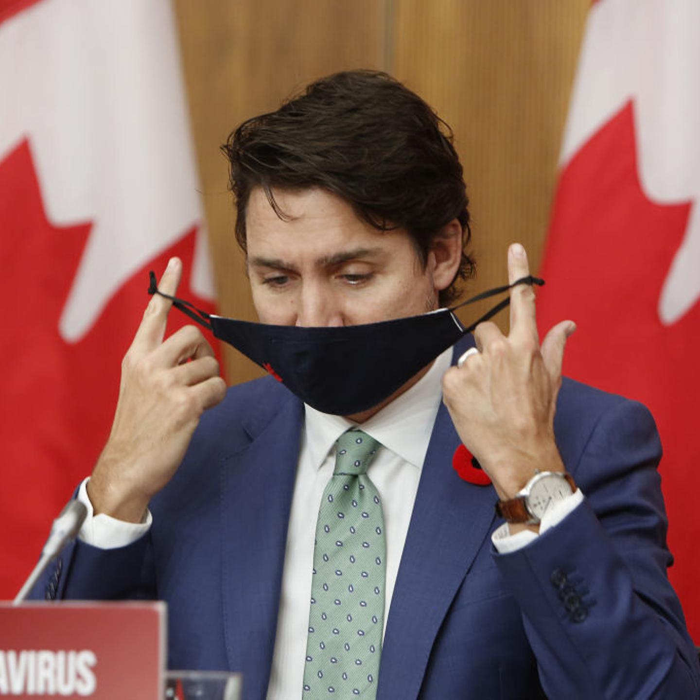 Justin Trudeau, Canada's prime minister, takes off a protective mask during a news conference in Ottawa, Ontario, Canada, on Friday, Nov. 6, 2020.