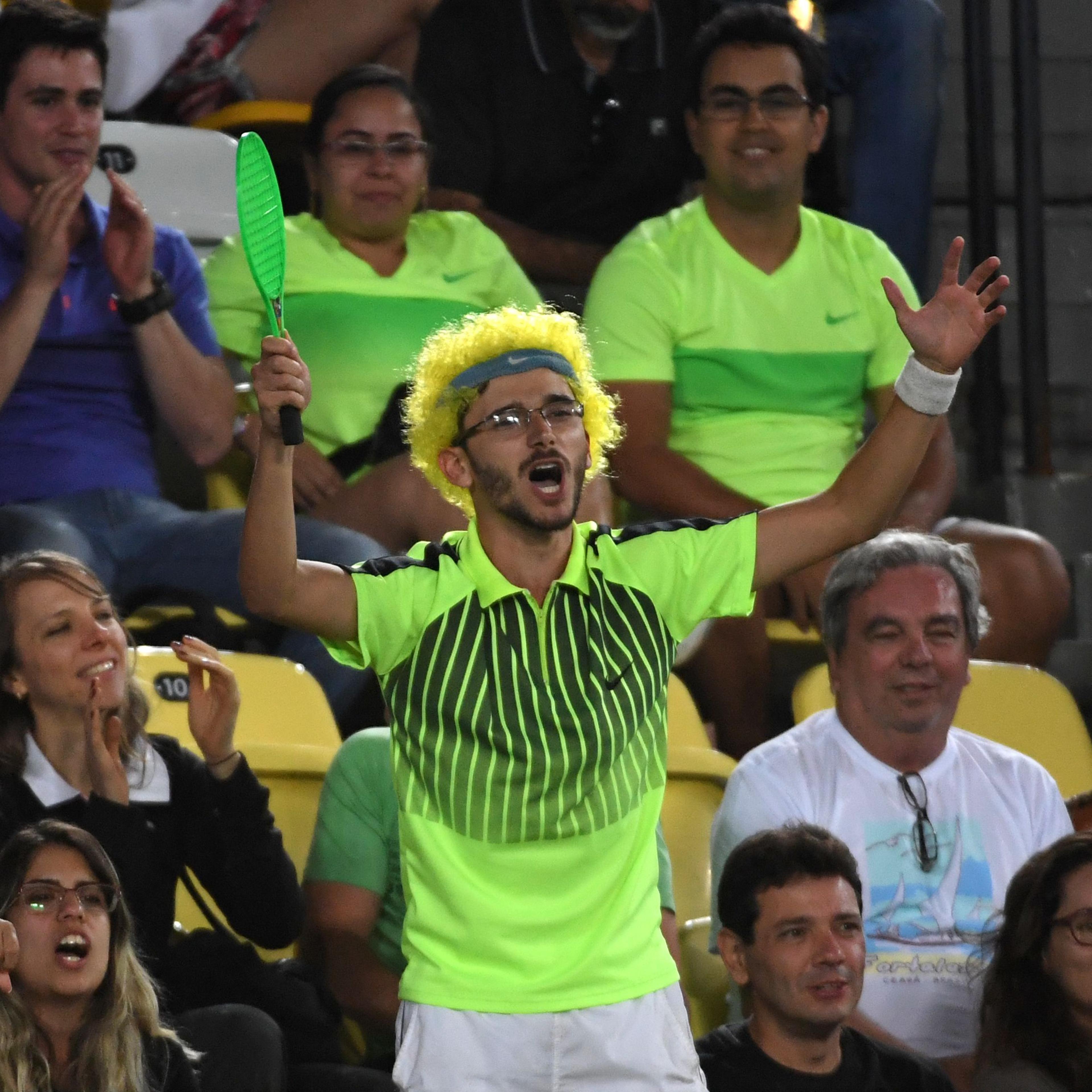 A fan wearing a green wig cheers during the men's second round singles tennis match between Japan's Kei Nishikori and Australia's John Millman at the Olympic Tennis Centre of the Rio 2016 Olympic Games in Rio de Janeiro on August 8, 2016.