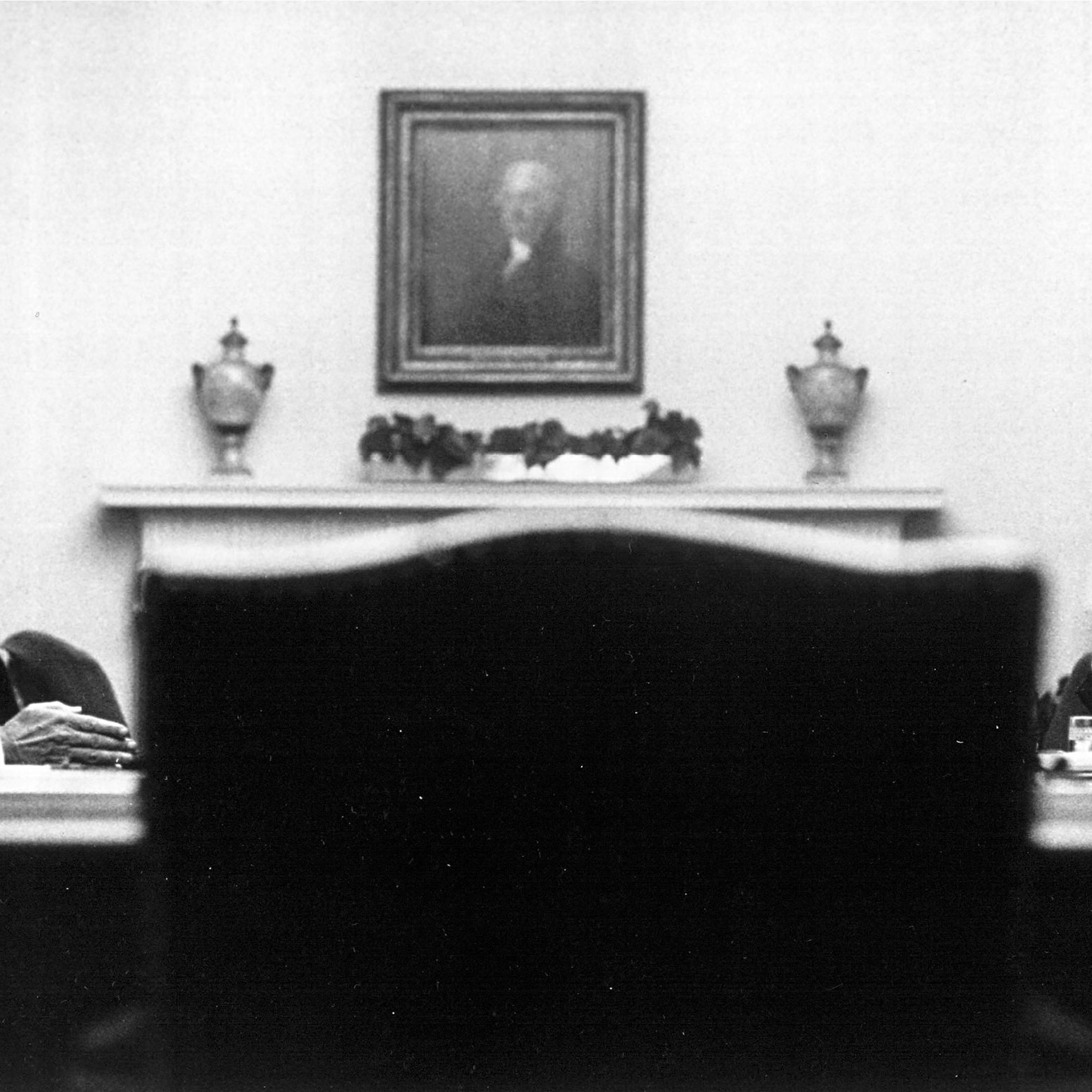 President Lyndon Johnson sits across a table from Richard Nixon in a meeting room in the white house