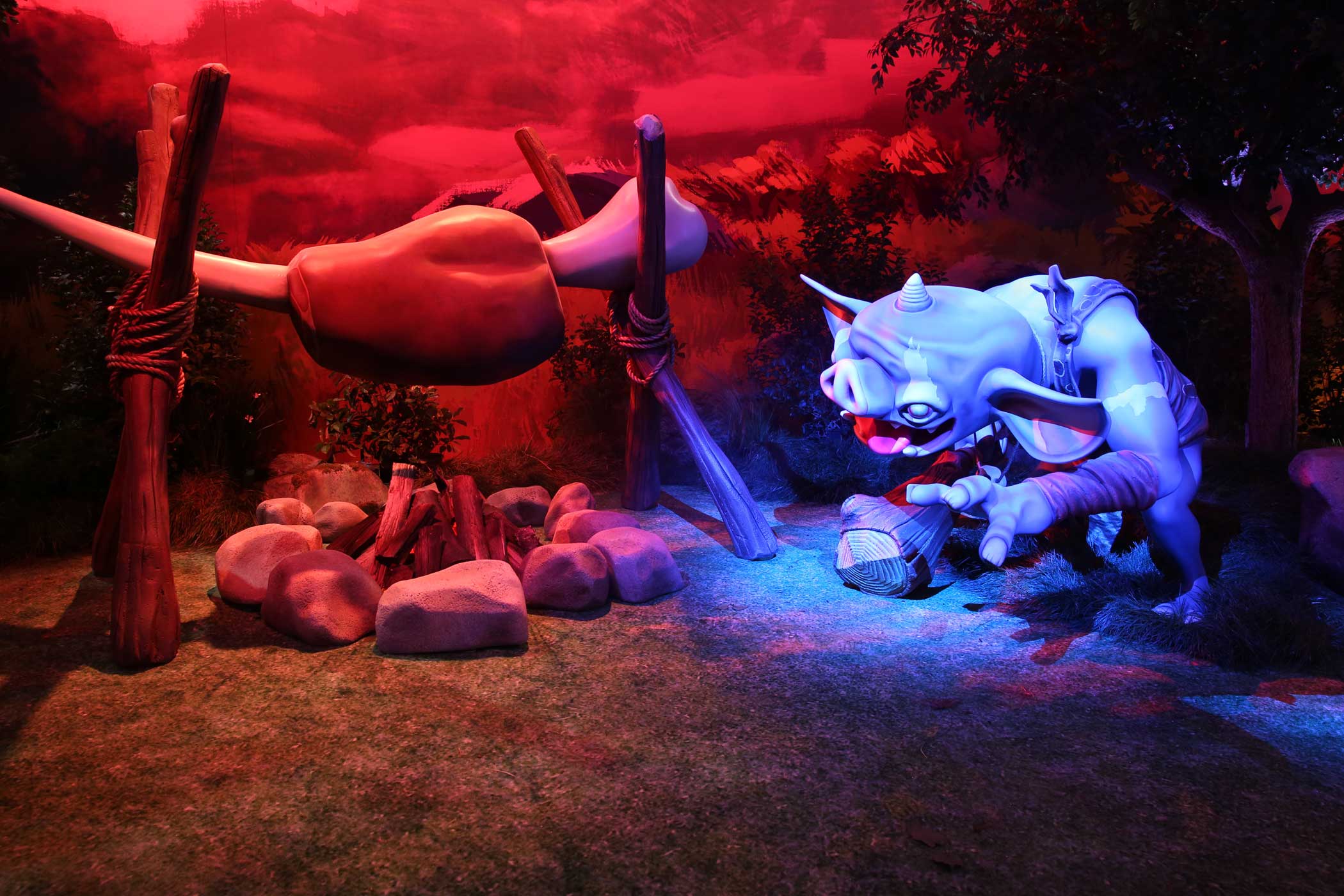 A goblin hunkers near a campfire.