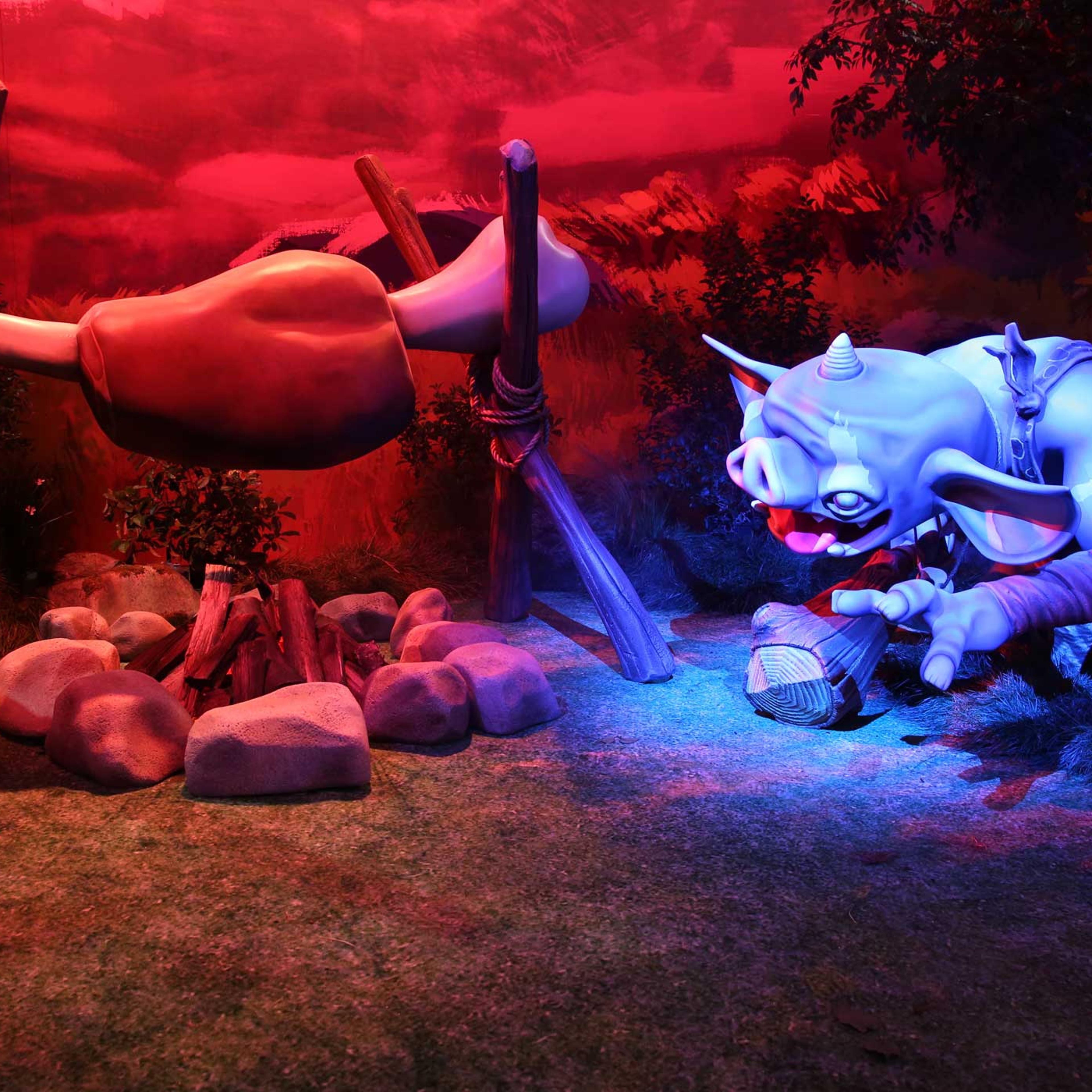 A goblin hunkers near a campfire.