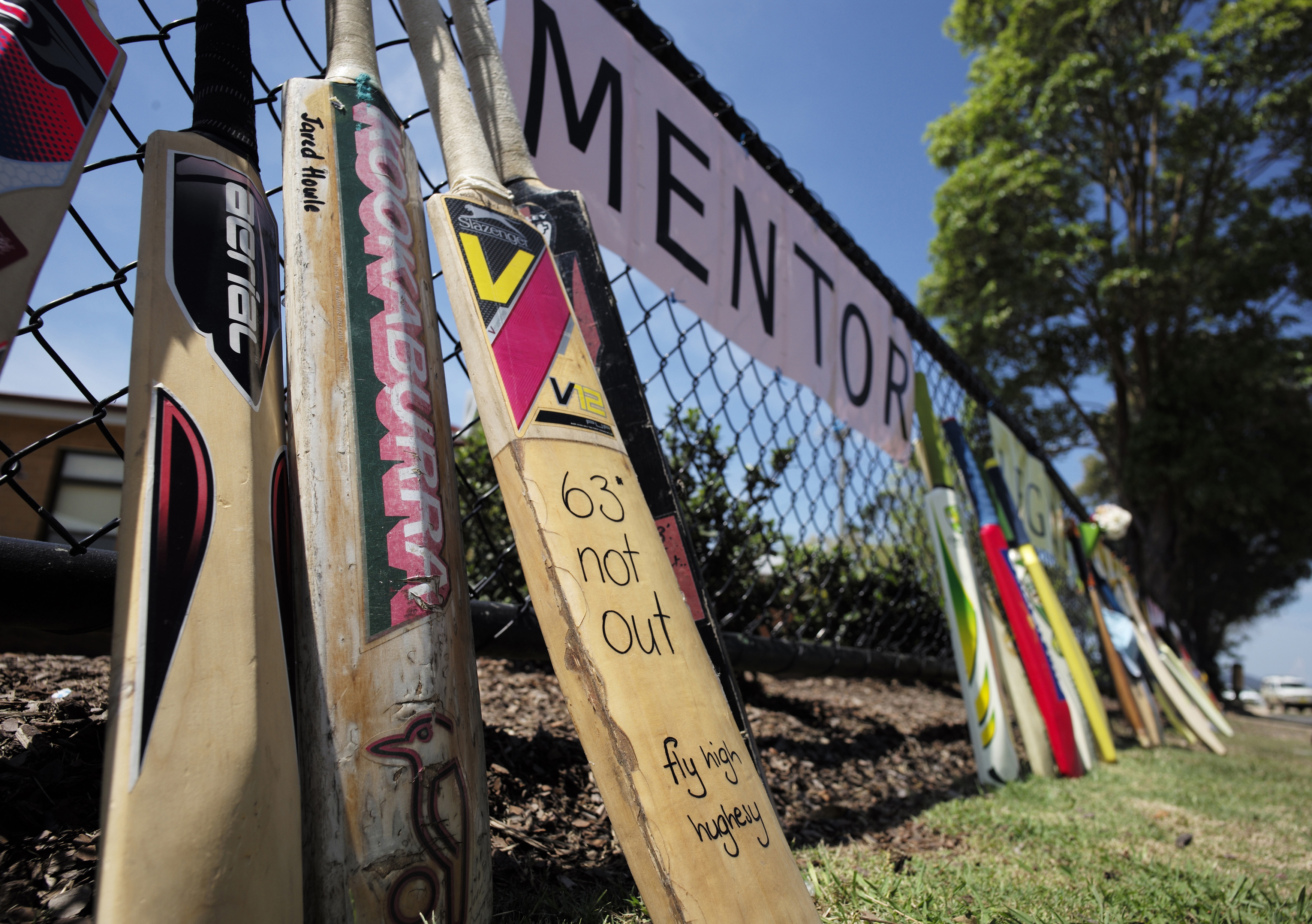 Cricket bats line the funeral procession route for Australian cricketer Phillip Hughes outside a primary school in his home town of Macksville