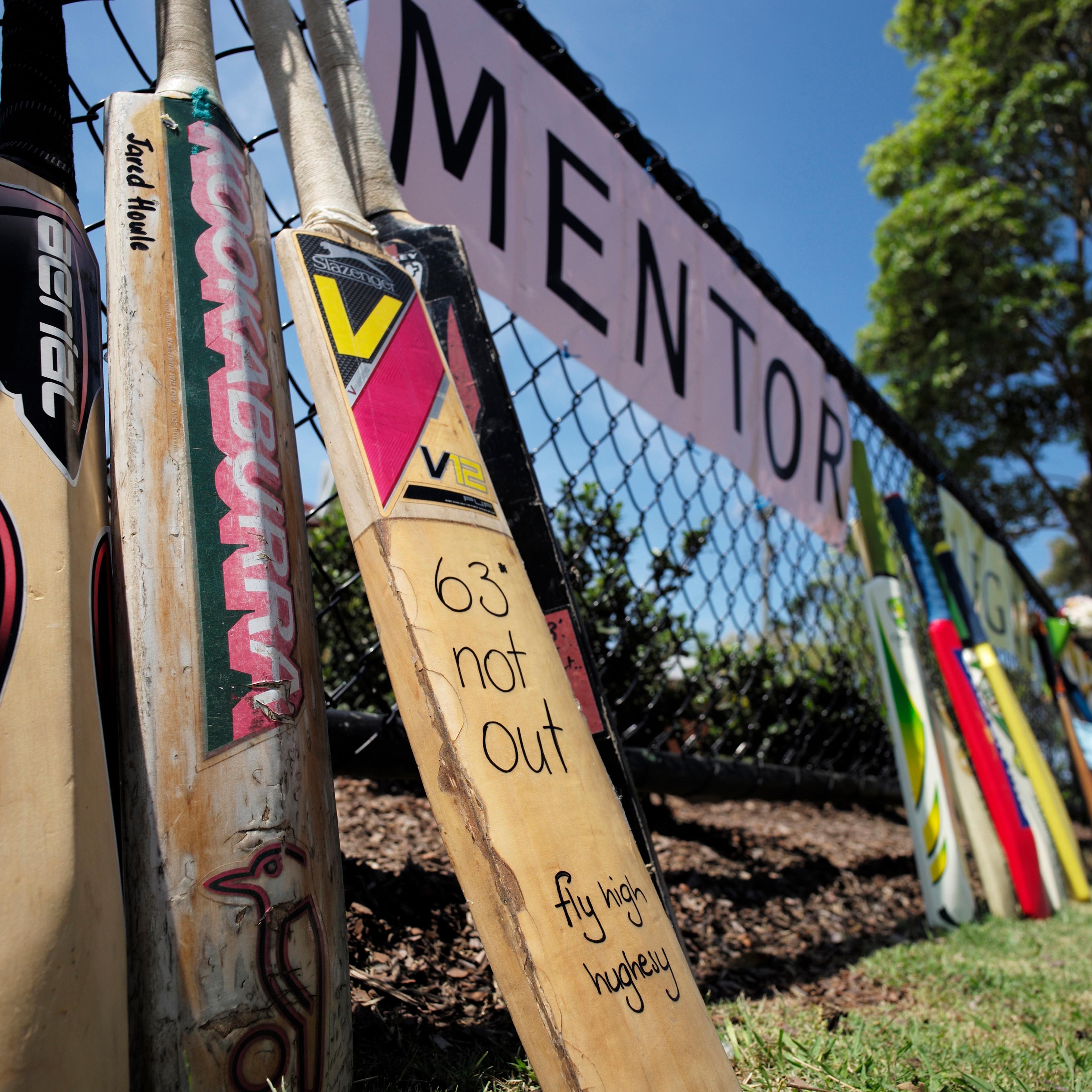 Cricket bats line the funeral procession route for Australian cricketer Phillip Hughes outside a primary school in his home town of Macksville