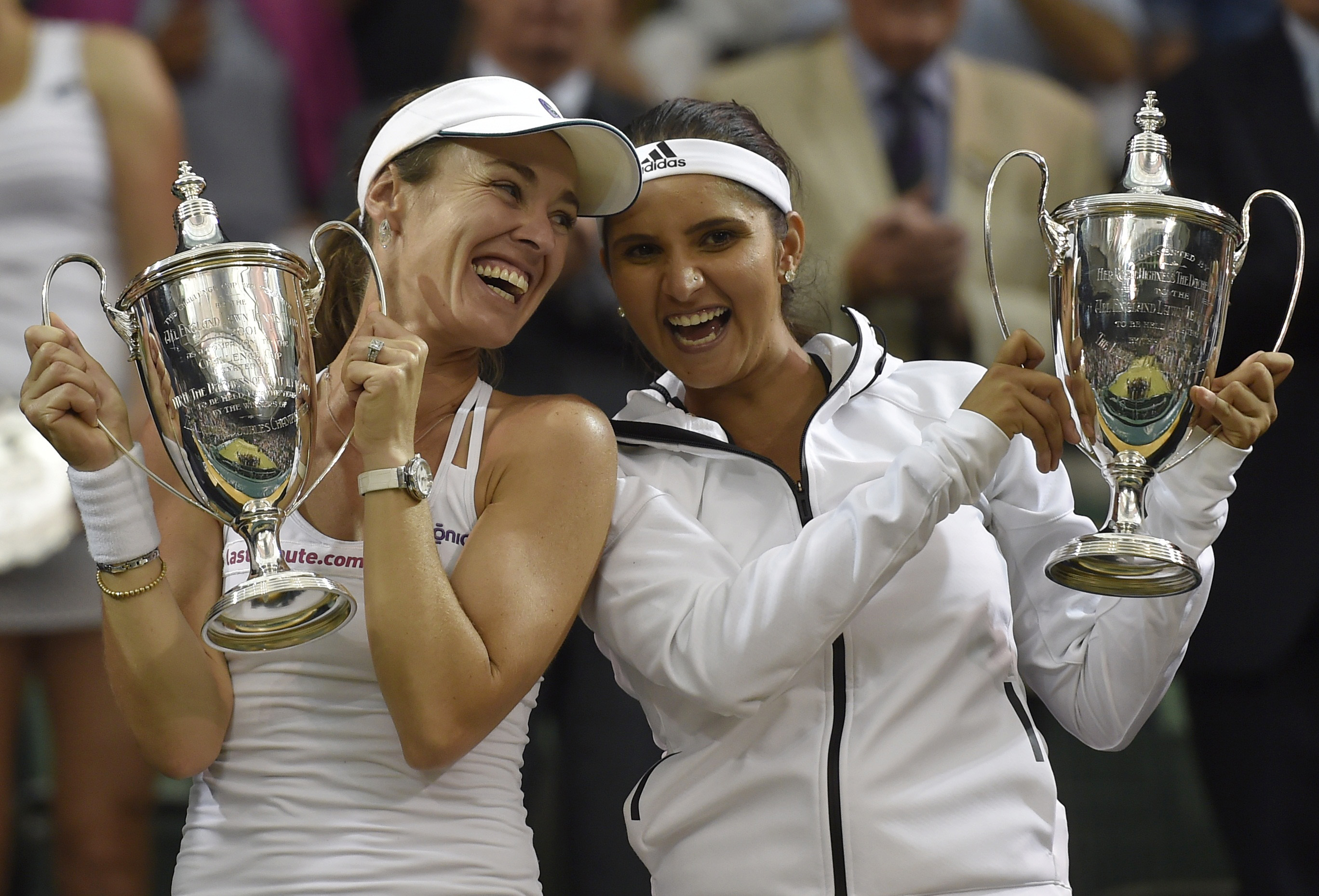Martina Hingis of Switzerland and Sania Mirza of India pose with their trophies after winning their Women's Doubles Final match against Elena Vesnina and Ekaterina Makarova of Russia at the Wimbledon Tennis Championships in London