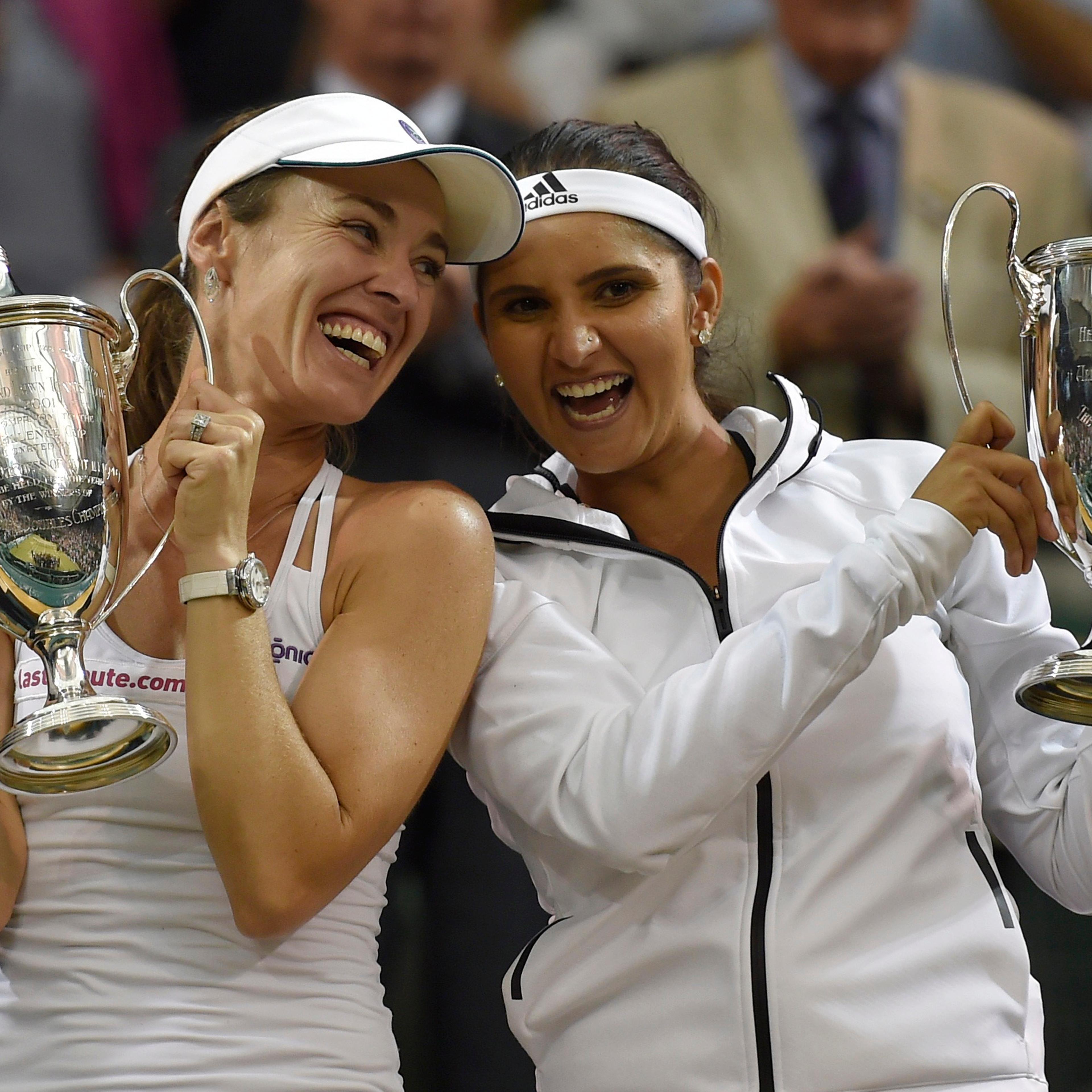 Martina Hingis of Switzerland and Sania Mirza of India pose with their trophies after winning their Women's Doubles Final match against Elena Vesnina and Ekaterina Makarova of Russia at the Wimbledon Tennis Championships in London