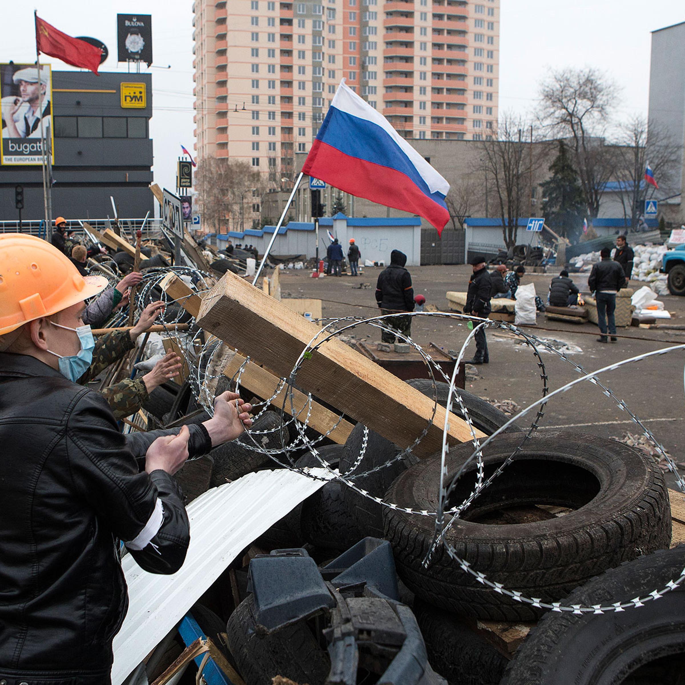 Pro-Russian protesters set a barbed wire on a barricade outside the SBU state security service in Luhansk, in eastern Ukraine, April 10, 2014.