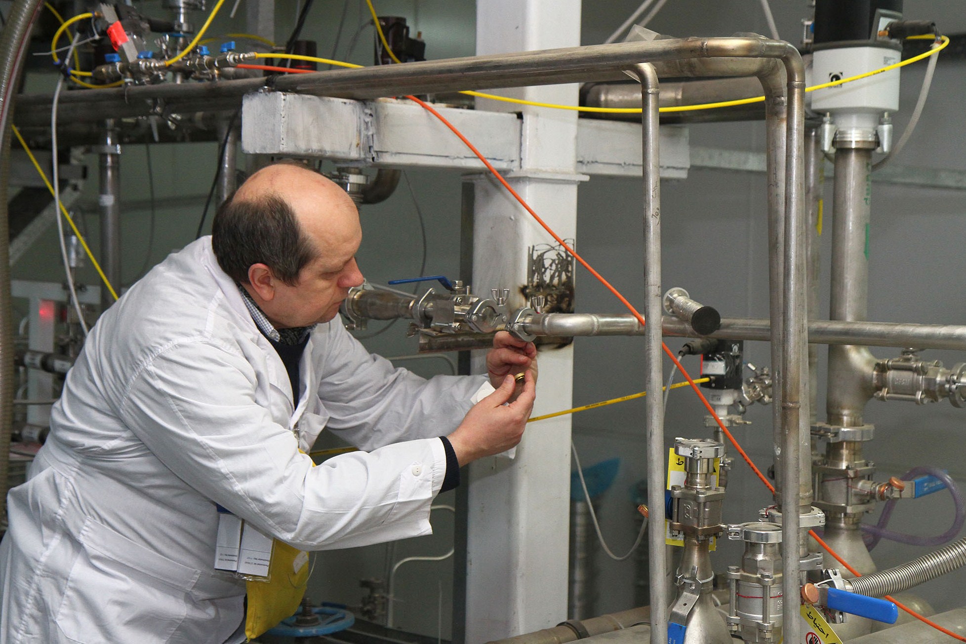 An International Atomic Energy Agency (IAEA) inspector disconnects the connections between the twin cascades for 20 percent uranium production at nuclear power plant of Natanz, some 300 kilometres south of Tehran on Jan. 20, 2014.