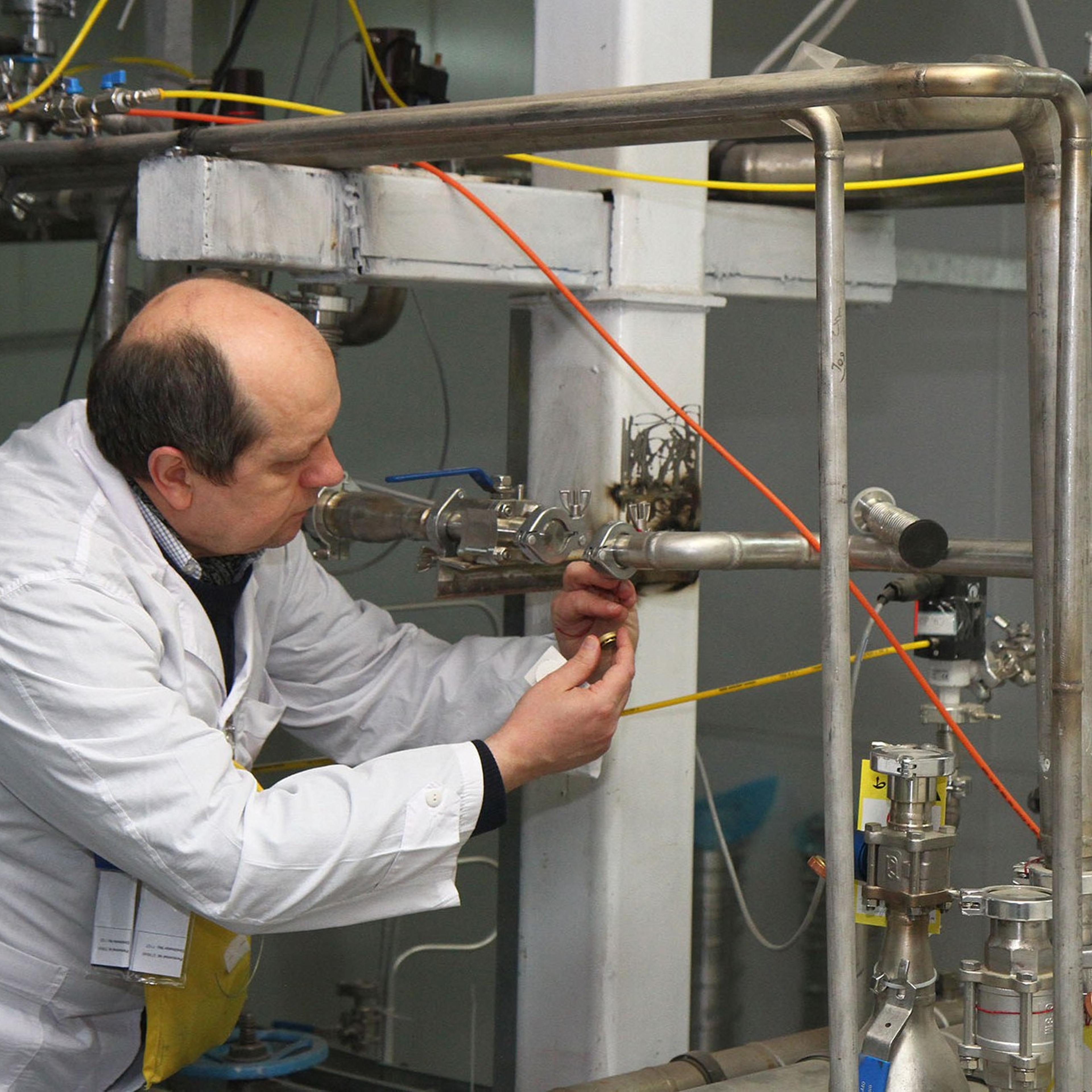 An International Atomic Energy Agency (IAEA) inspector disconnects the connections between the twin cascades for 20 percent uranium production at nuclear power plant of Natanz, some 300 kilometres south of Tehran on Jan. 20, 2014.