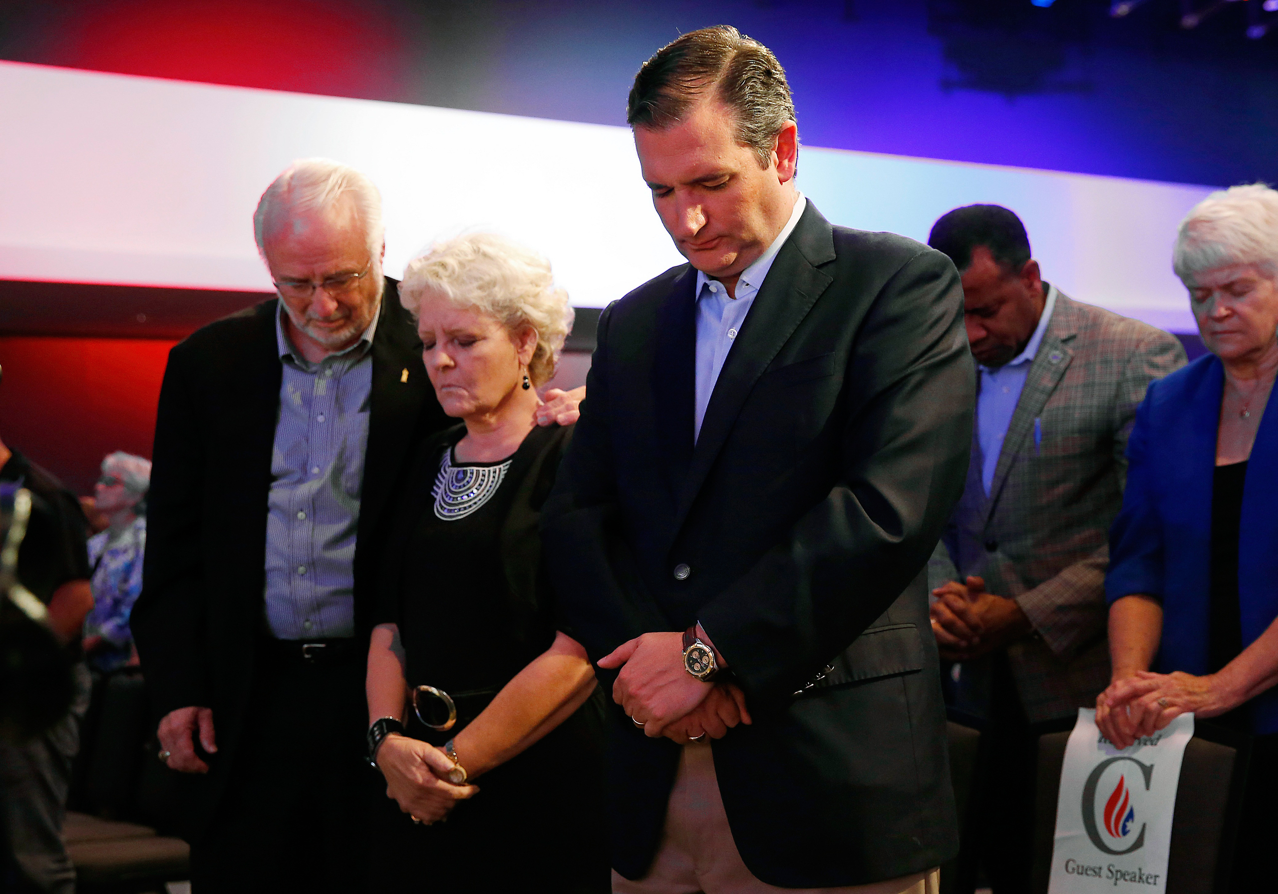 Cruz prays with Iowans Dick and Betty Odgaard, left, at a rally for religious liberty in Des Moines in August