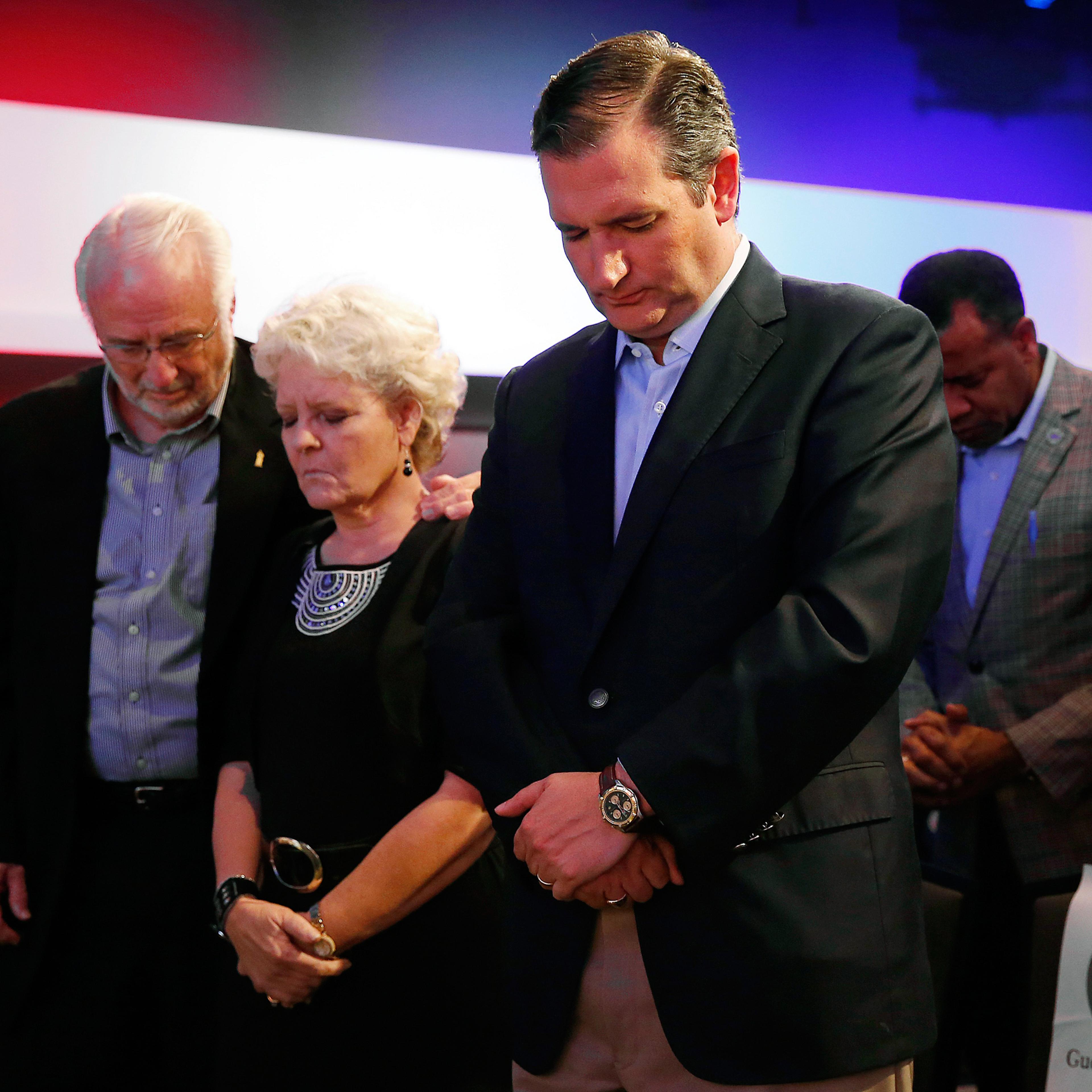 Cruz prays with Iowans Dick and Betty Odgaard, left, at a rally for religious liberty in Des Moines in August