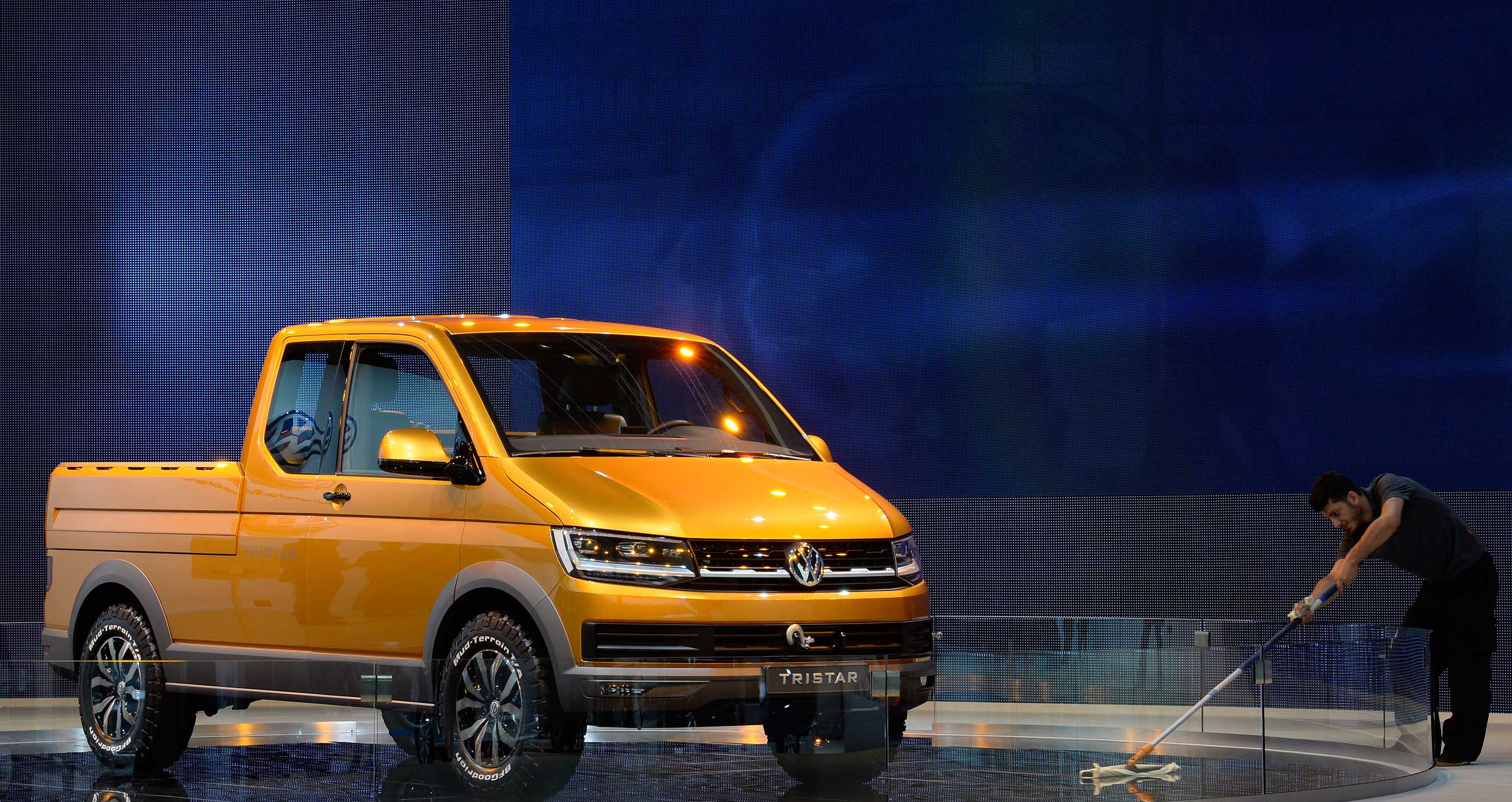 A worker cleans the floor beside Volkwagen's new concept car "TRISTAR" at the booth of German carmaker Volkswagen Nutzfahrzeuge ( Volkswagen Commercial Vehicles) at the IAA truck show in Hanover on Sept. 23, 2014.