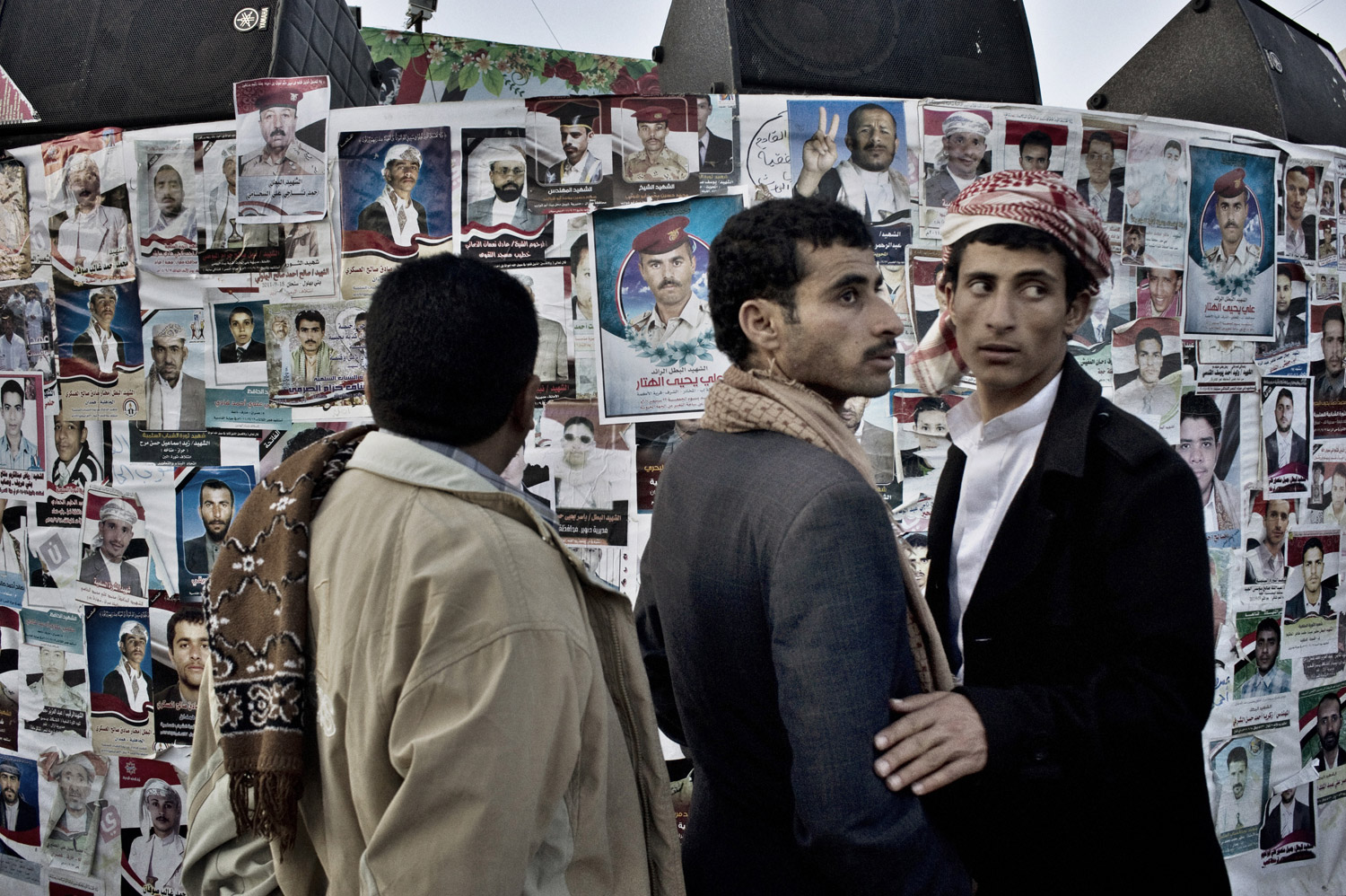Protestors gather in Change Square in Sana'a on October 1, 2011, near the makeshift prayer wall adorned with portraits of those killed in clashes with security forces.