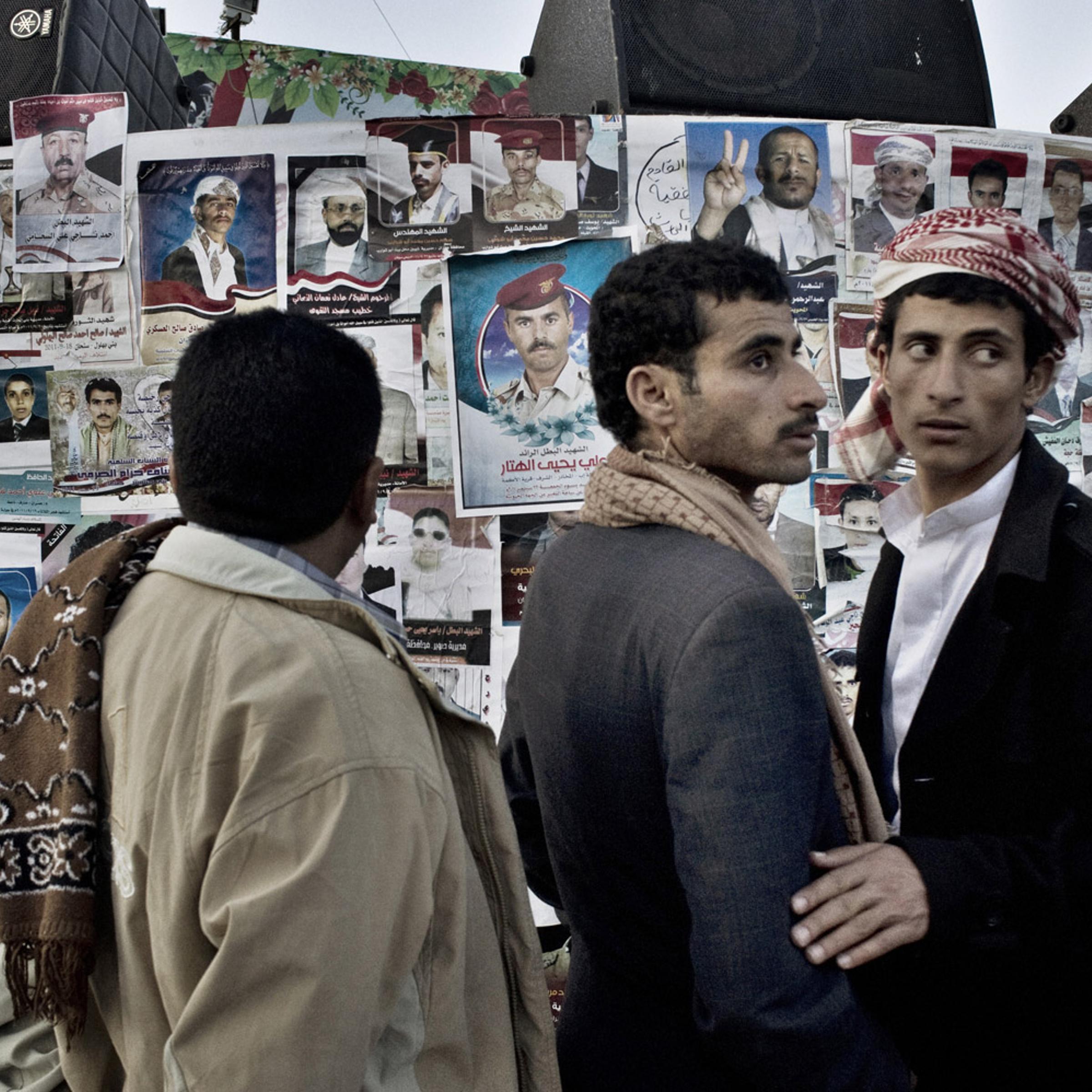 Protestors gather in Change Square in Sana'a on October 1, 2011, near the makeshift prayer wall adorned with portraits of those killed in clashes with security forces.