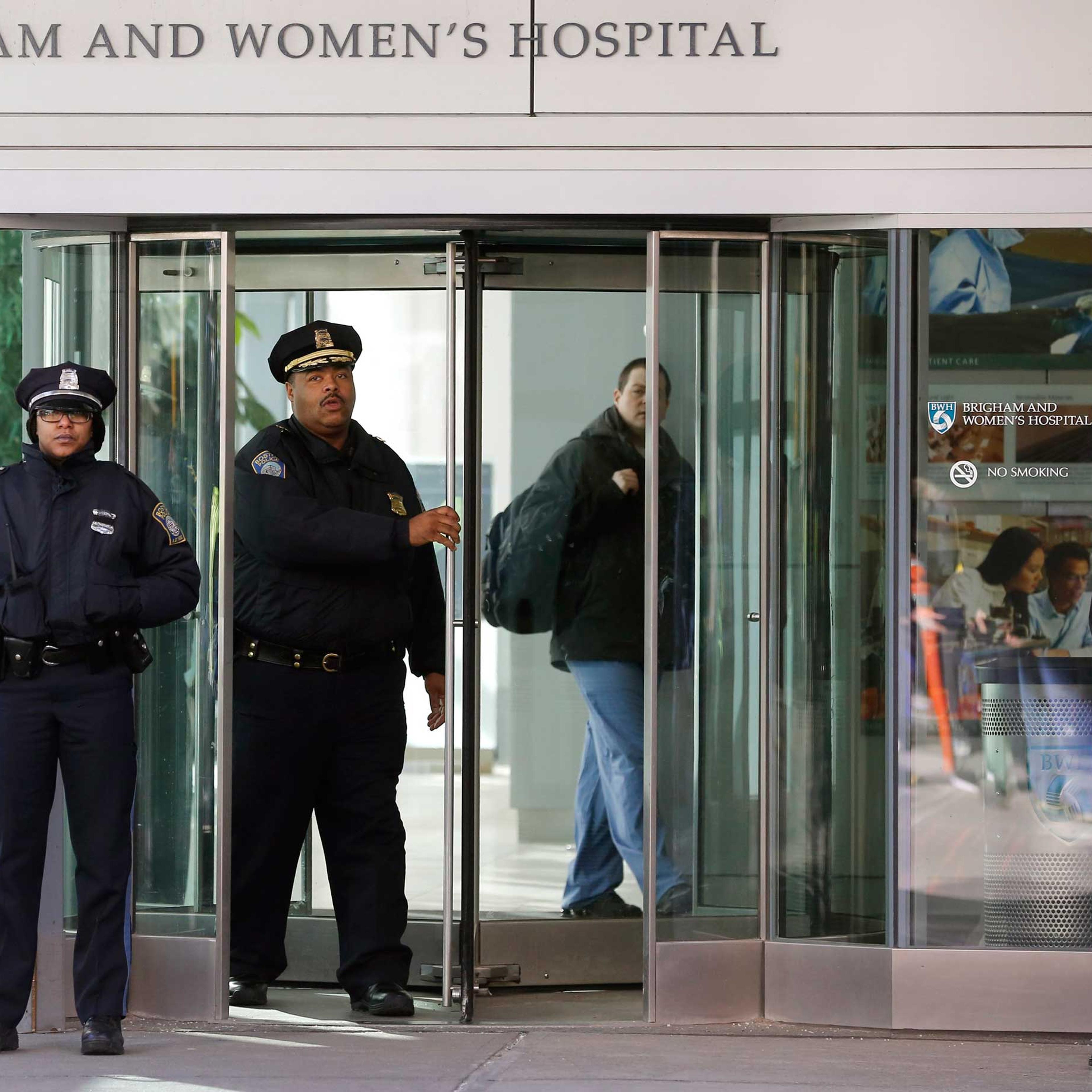 Boston Police Superintendent-in-Chief William Gross, center left, walks through a revolving door as he departs the Shapiro building at Brigham and Women's Hospital, Jan. 20, 2015 in Boston.
