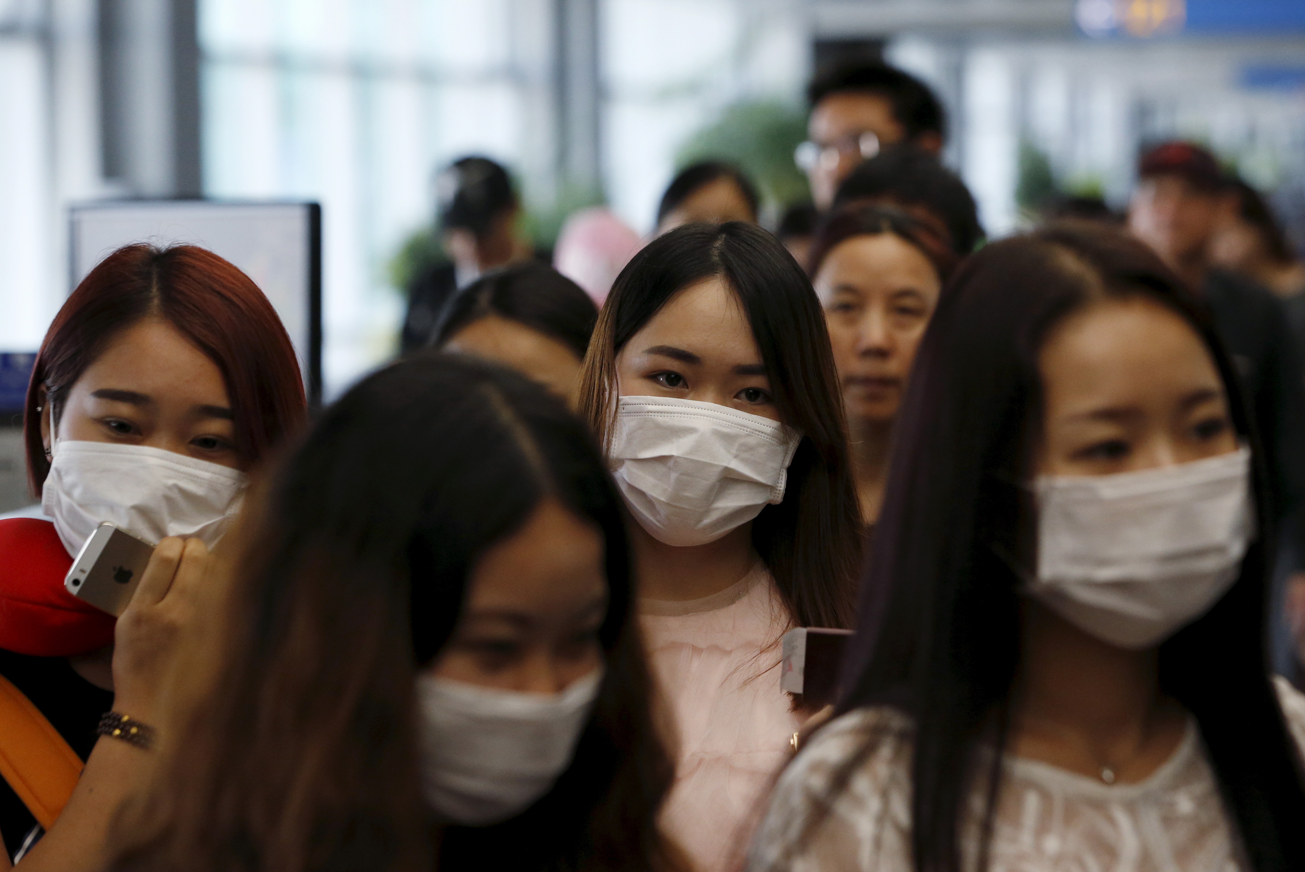 Passengers wearing masks to prevent contracting Middle East Respiratory Syndrome (MERS) walk past a thermal imaging camera (unseen) at Incheon International Airport in South Korea, June 2, 2015.