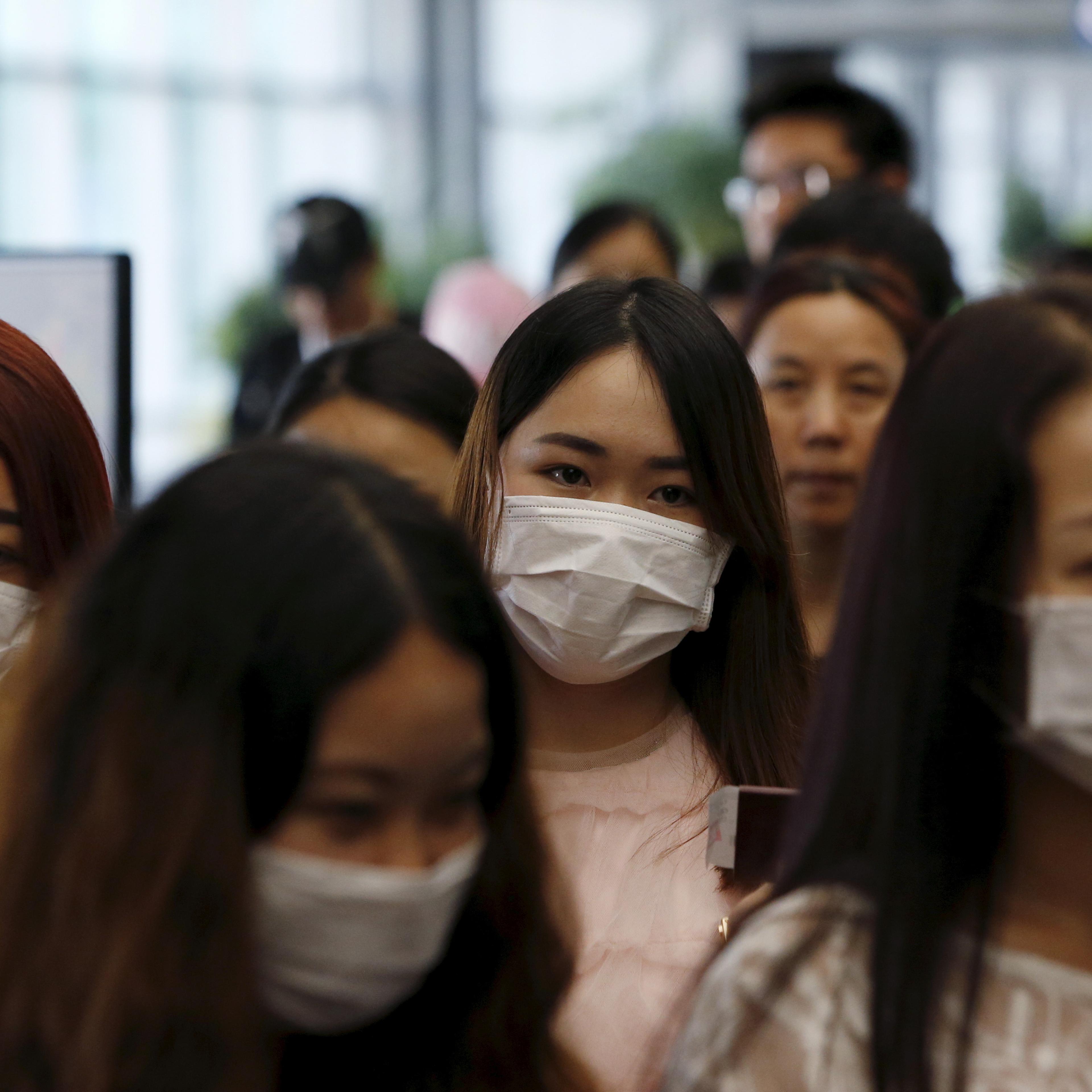 Passengers wearing masks to prevent contracting Middle East Respiratory Syndrome (MERS) walk past a thermal imaging camera (unseen) at Incheon International Airport in South Korea, June 2, 2015.