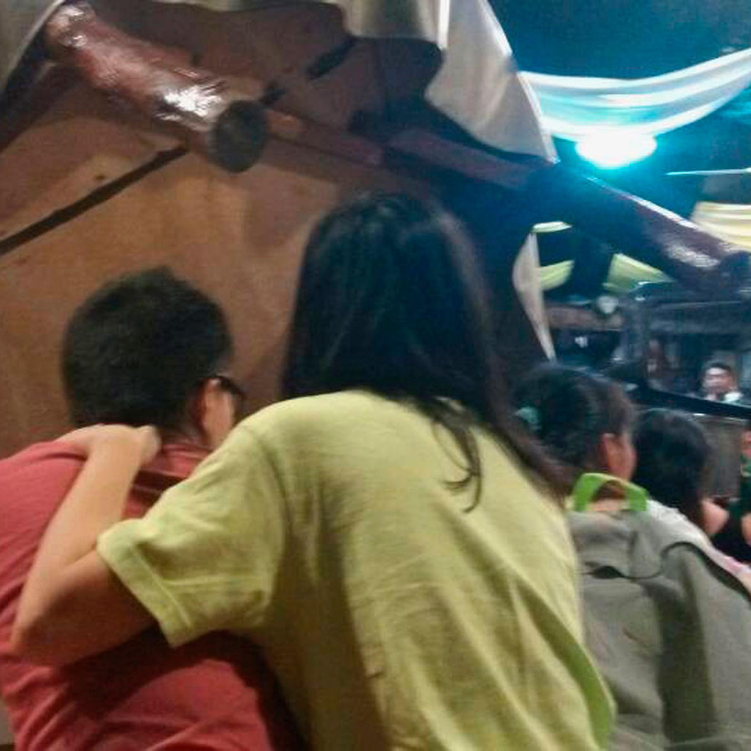 Tourists take cover on the floor next to an overturned table as armed men occupy a hotel in Sabah, April 2, 2014.