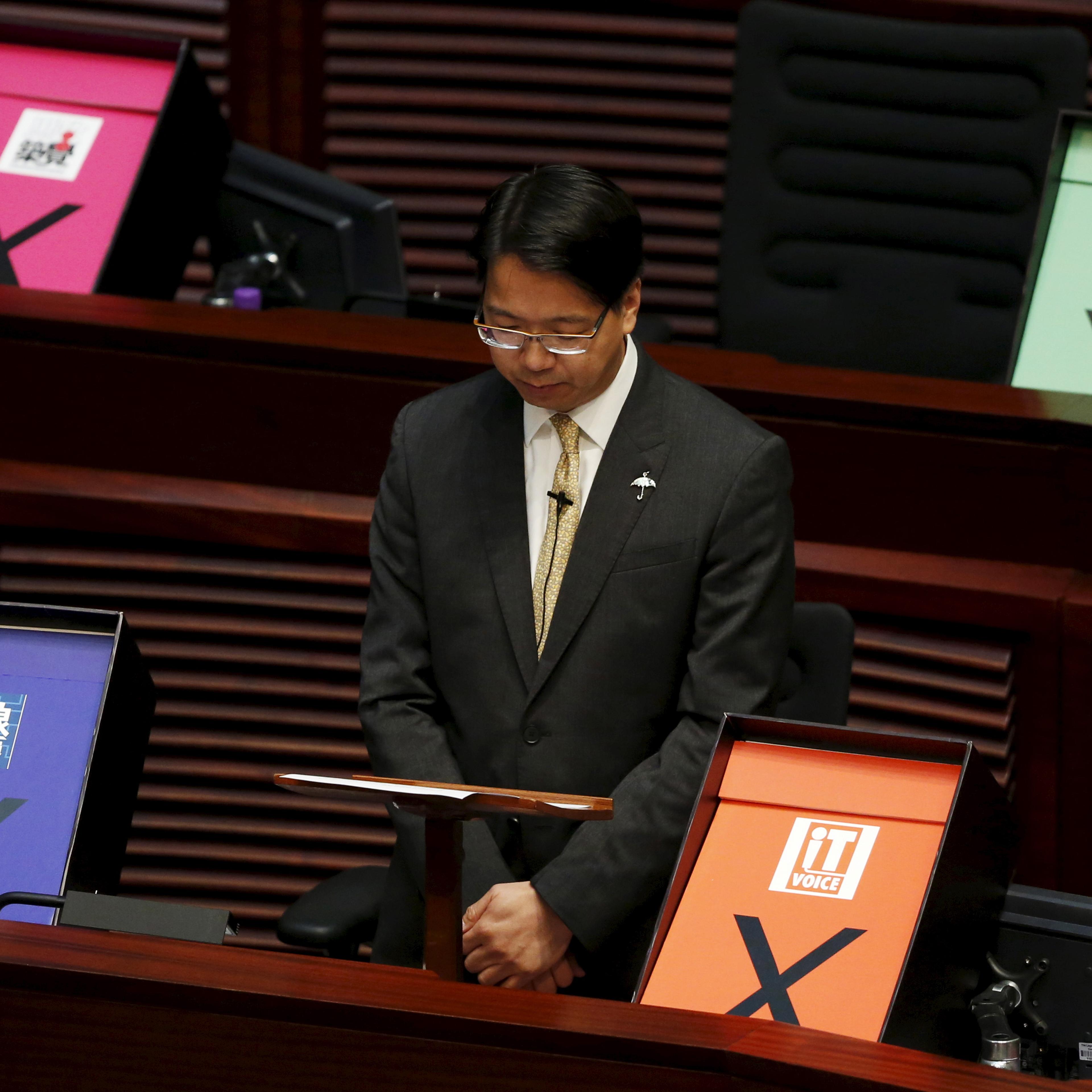 Pro-democracy lawmaker and I.T. advocate Mok is surrounded by veto signs during his speech at the Legislative Council meeting in Hong Kong