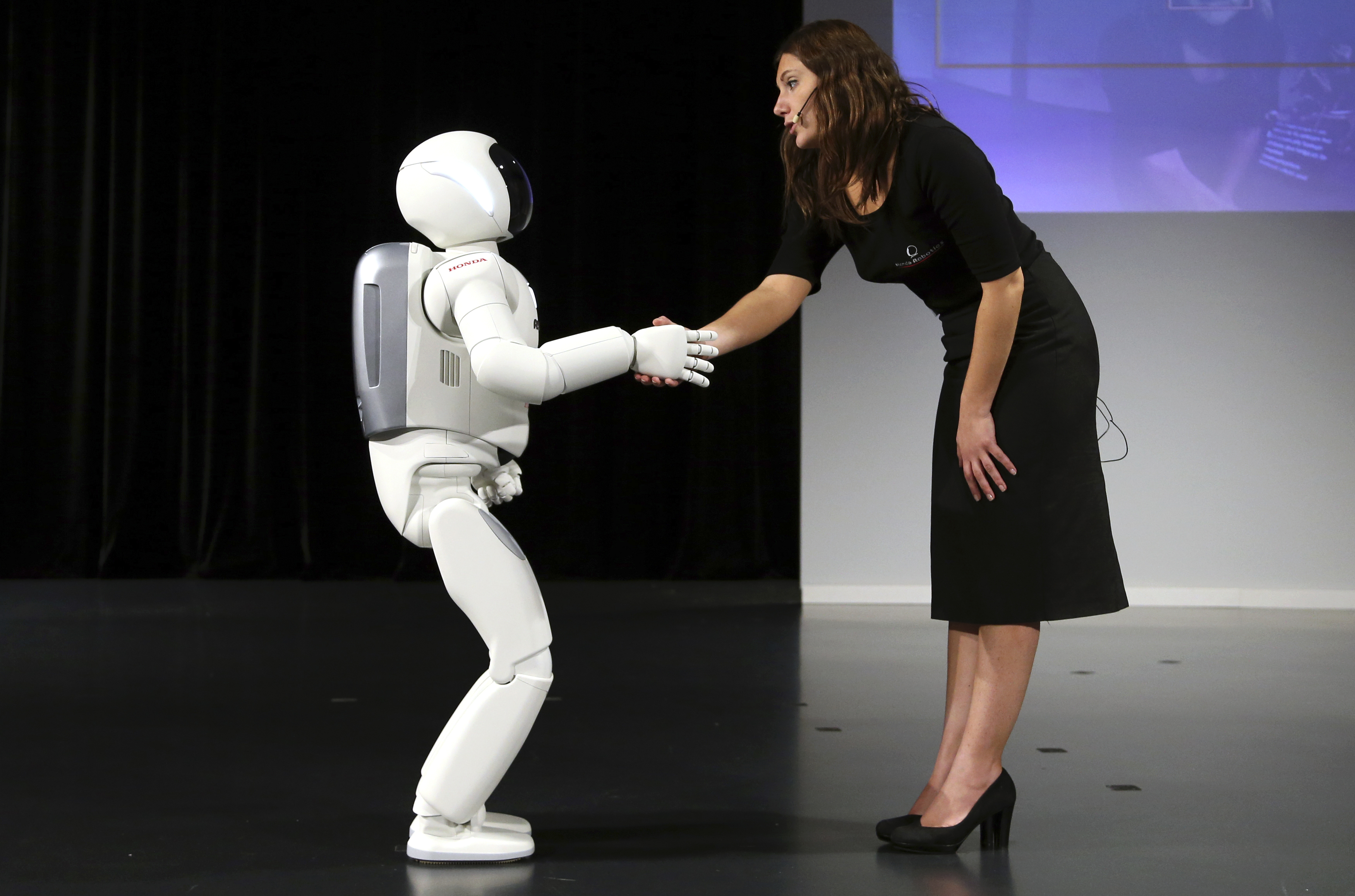 Honda's latest version of the Asimo humanoid robot shakes hands during a presentation in Zaventem near Brussels