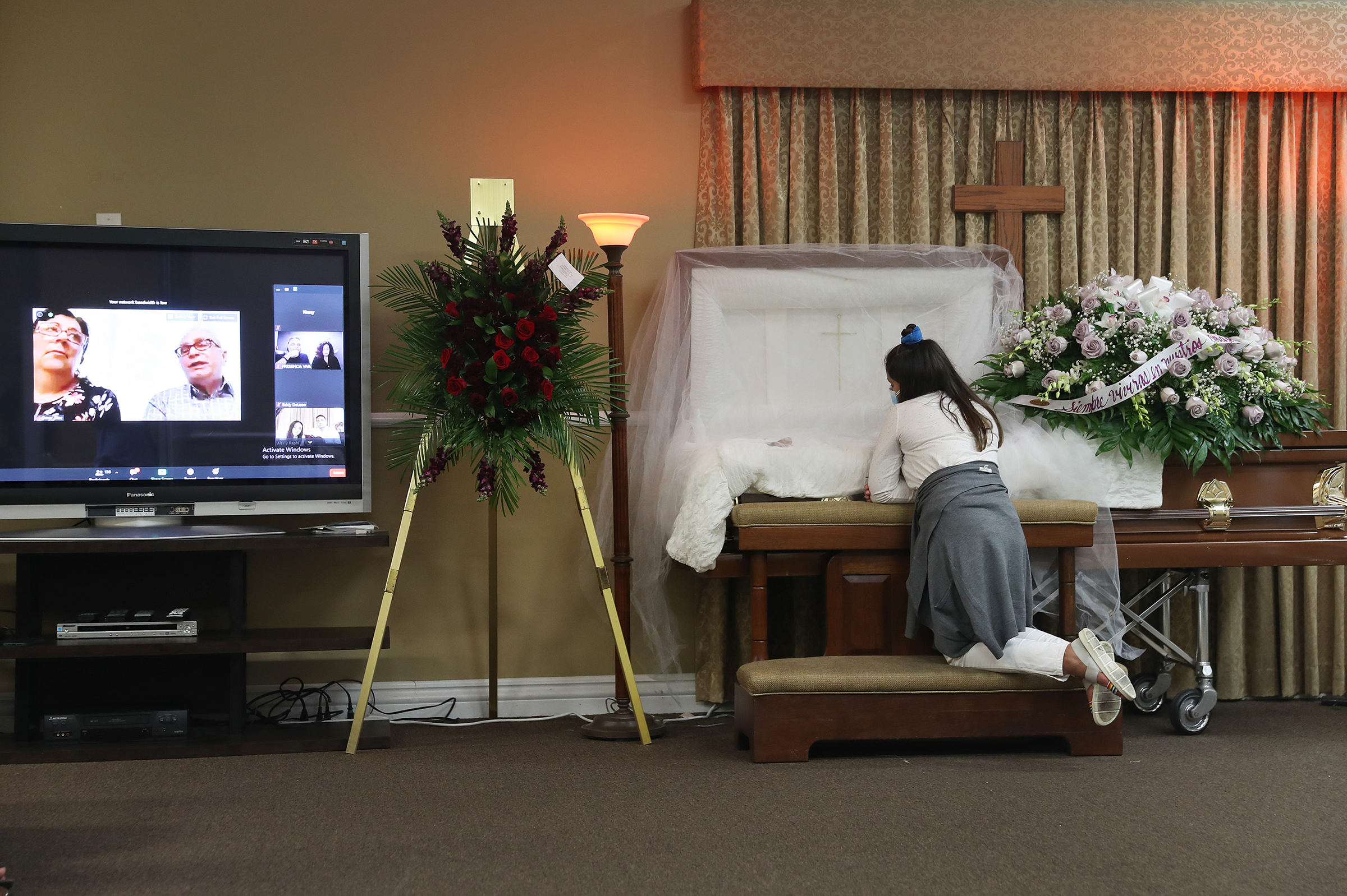 Asare Amaya, 10, mourns for her father, German Amaya, as family and friends are shown via a Zoom broadcast at the Maspons Funeral Home in Miami on Aug. 8, 2020. German Amaya, who died from COVID-19, had worked for 11 years at the Fontainebleau Miami Beac