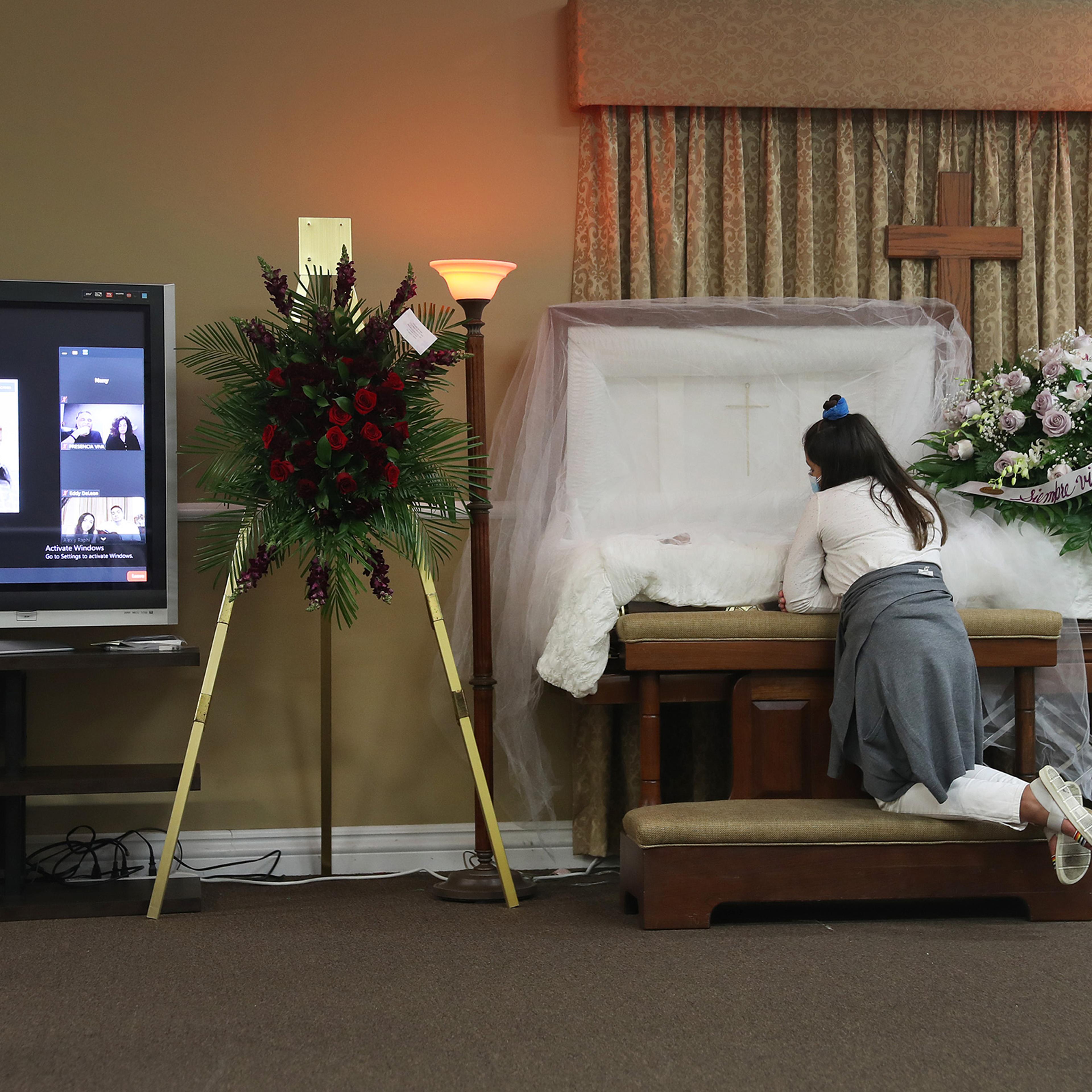 Asare Amaya, 10, mourns for her father, German Amaya, as family and friends are shown via a Zoom broadcast at the Maspons Funeral Home in Miami on Aug. 8, 2020. German Amaya, who died from COVID-19, had worked for 11 years at the Fontainebleau Miami Beac