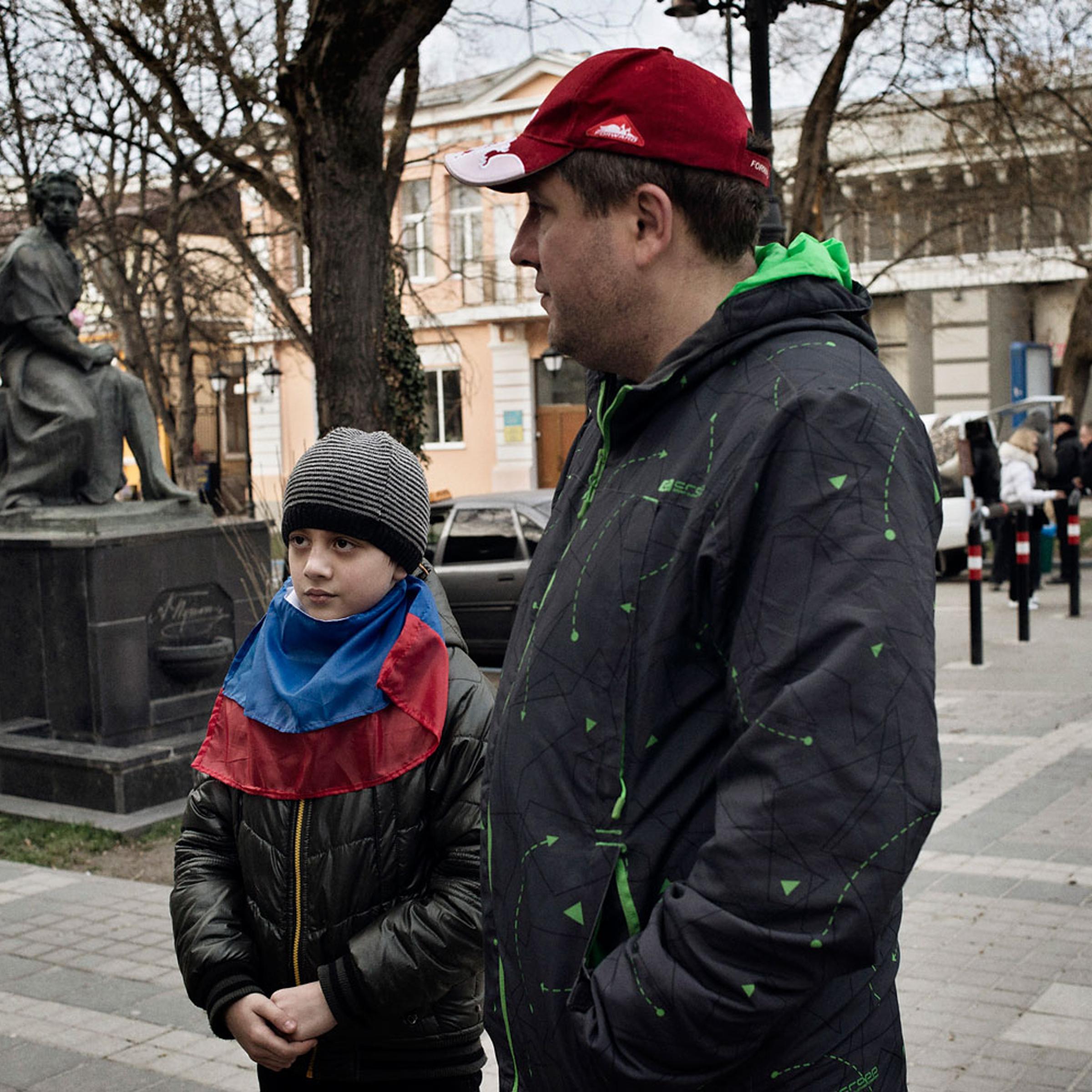 Ivan Drobkov, an ethnic Russian native of Crimea, walks near the regional parliament with his 9-year-old son Bogdan on March 17, 2014.
